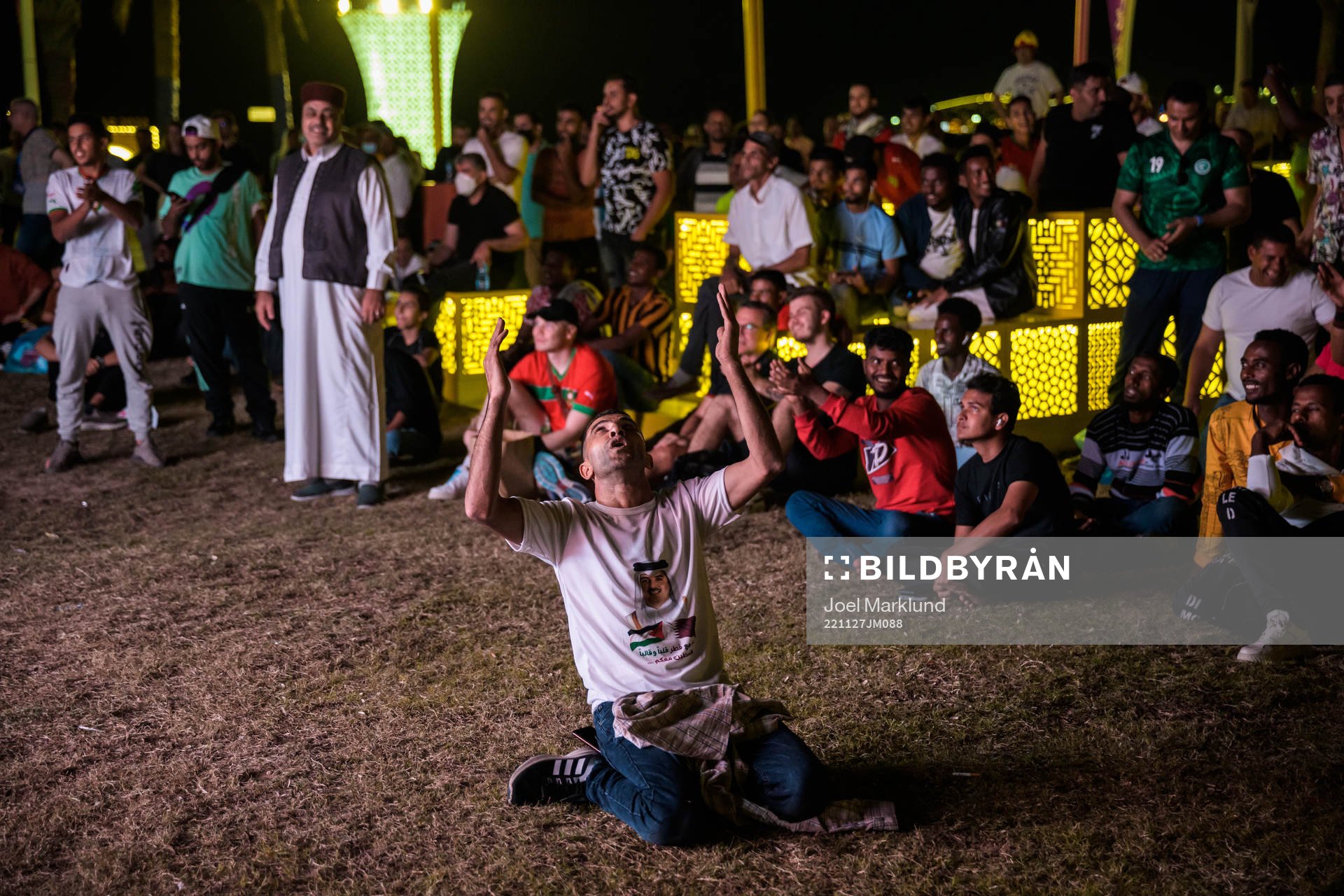 A man celebrates the 0-2 goal as he and others watch the