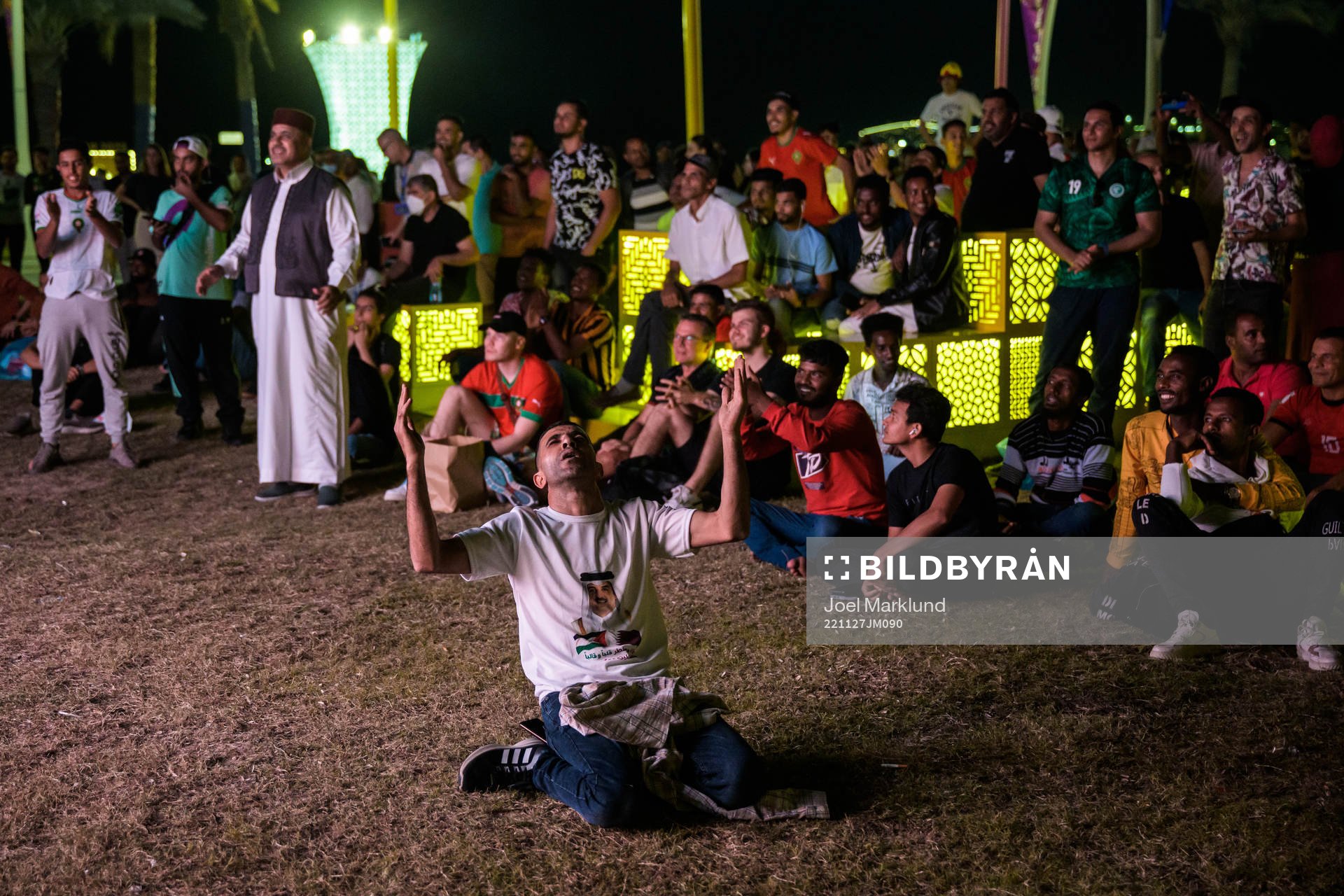 A man celebrates the 0-2 goal as he and others watch the match Belgium vs Morocco on an outdoor tv screen during day 8 of the FIFA World Cup 2022 on November 27, 2022 at Al Bidda Park in Doha. 