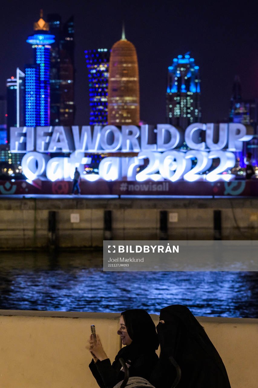 Qatari women in front of the FIFA World Cup logo