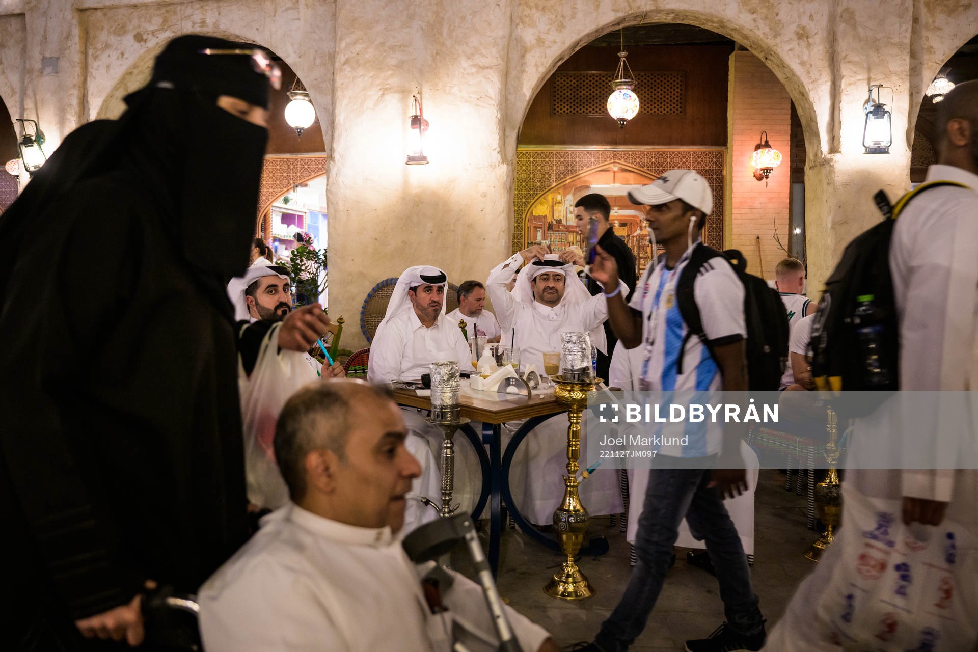 Qatari men see an Argentinian fan and Qatari woman in niqab
