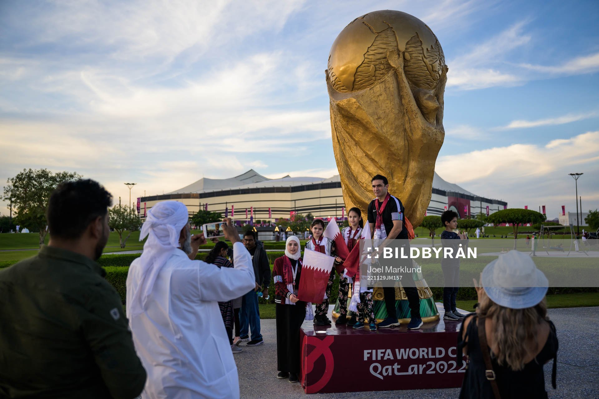 A family get their picture taken by a World Cup trophy