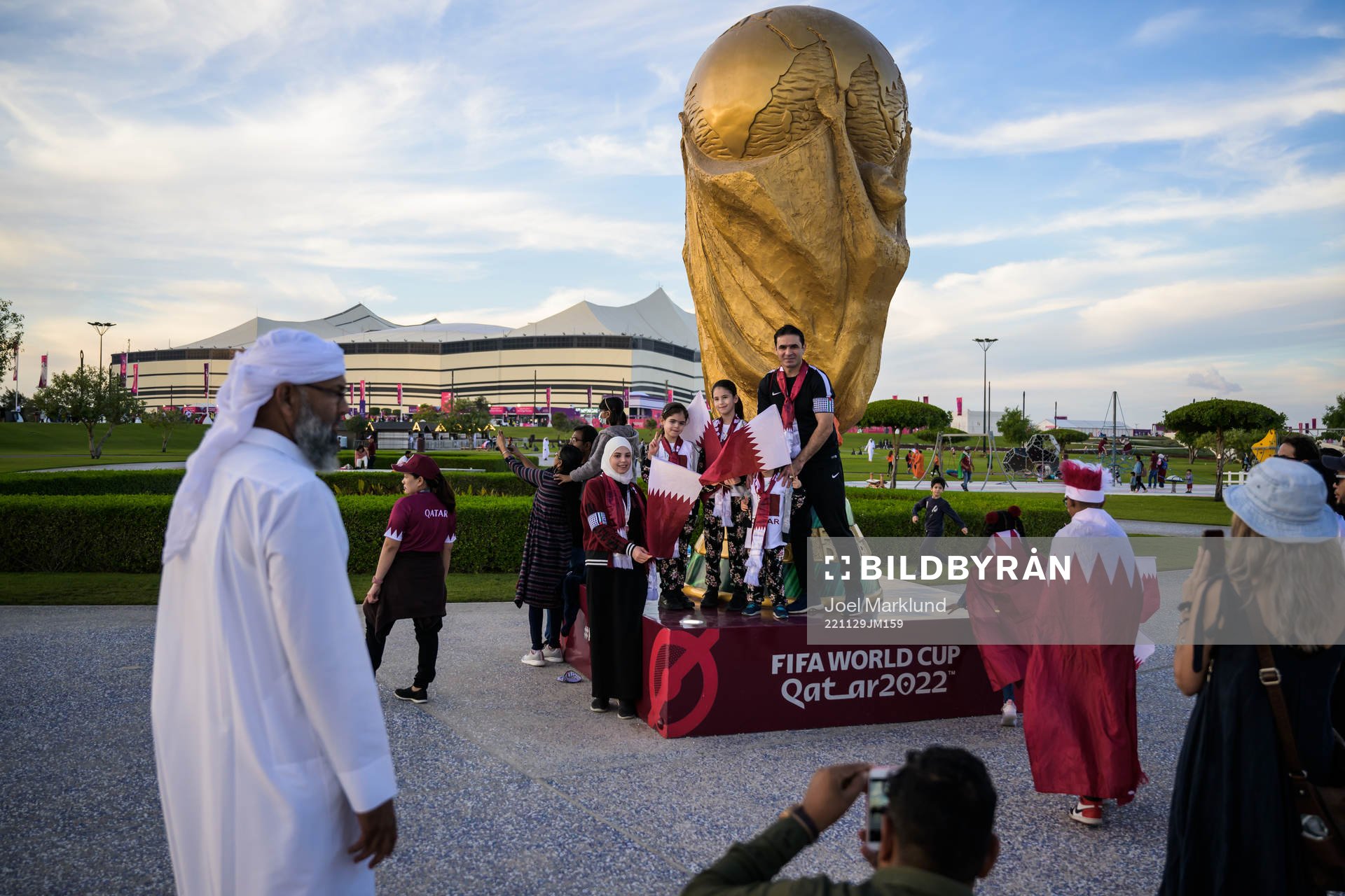 A family get their picture taken by a World Cup trophy