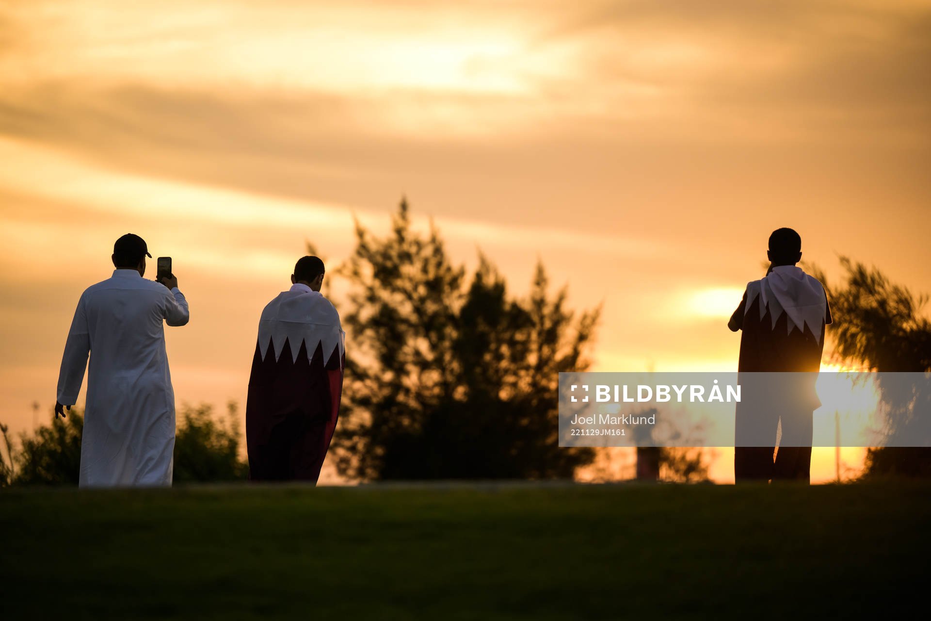 Men take pictures of the sunset