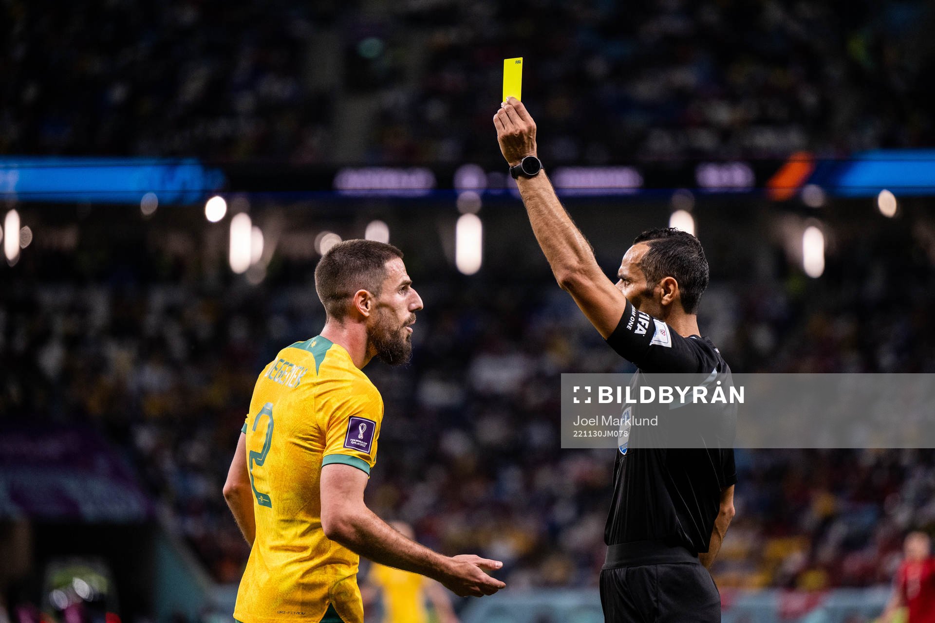 Milos Degenek of Australia is shown a yellow card by