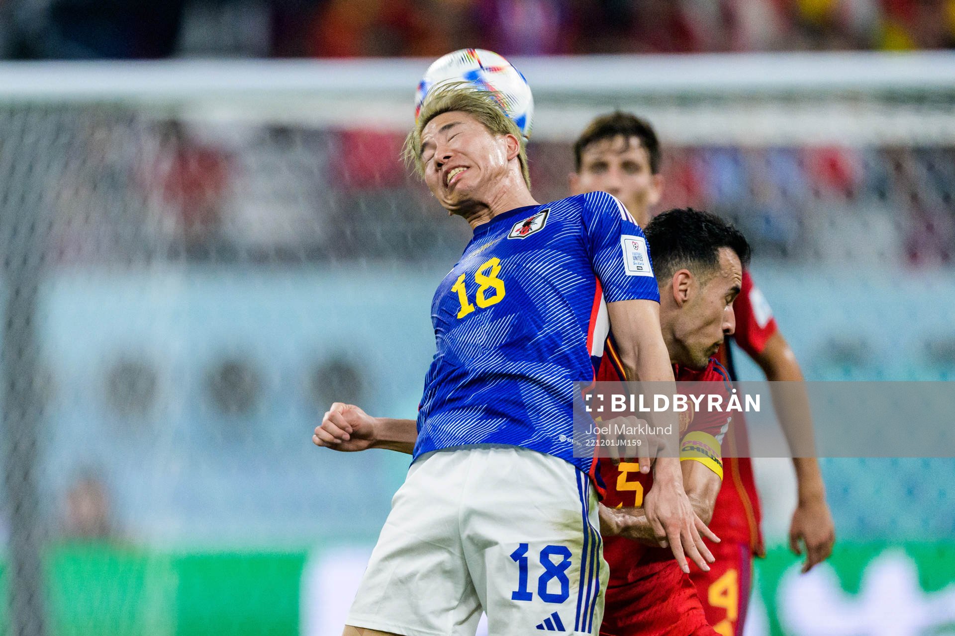 Takuma Asano of Japan and Sergio Busquets of Spain