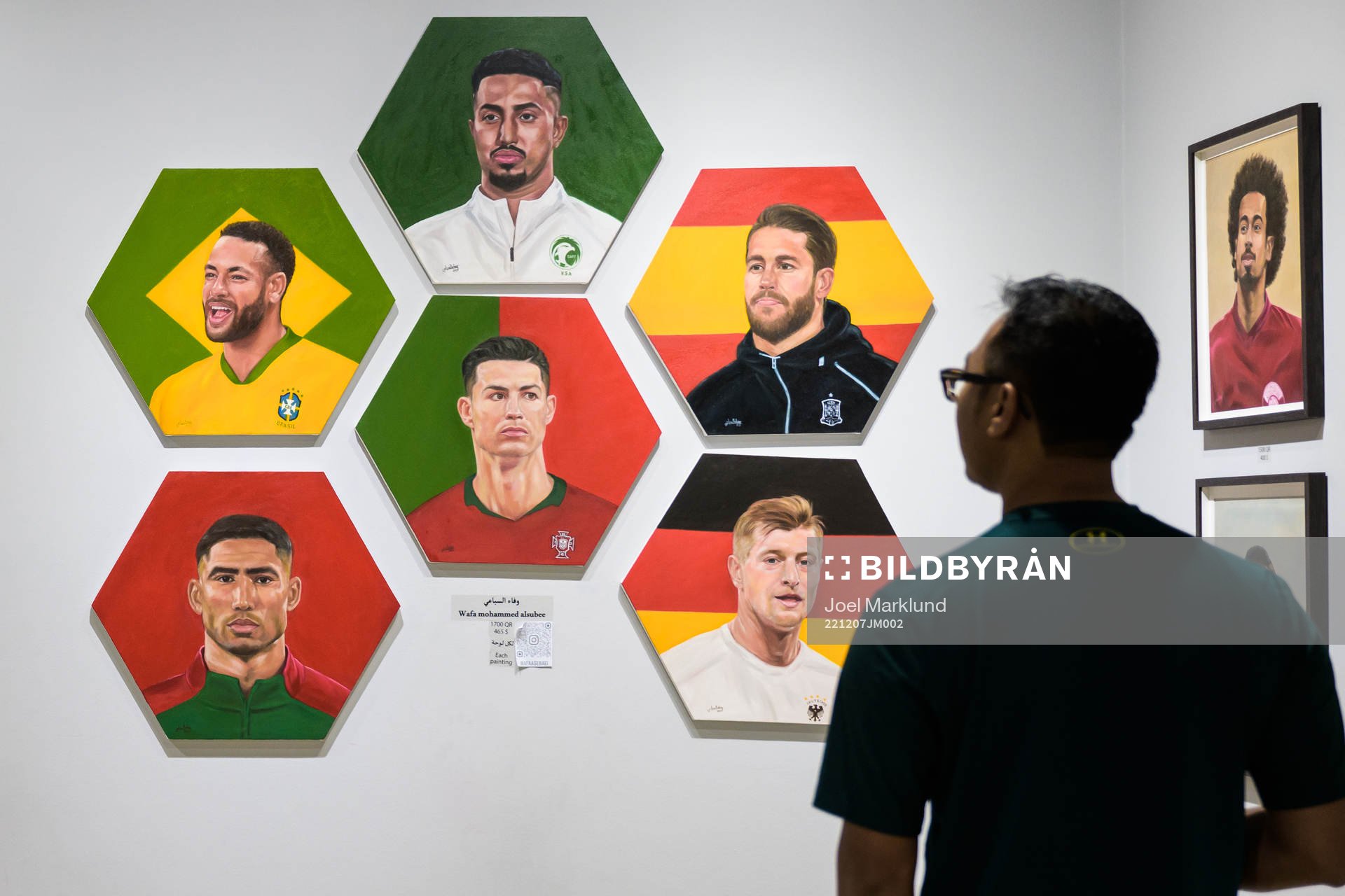A man watches paintings of football stars