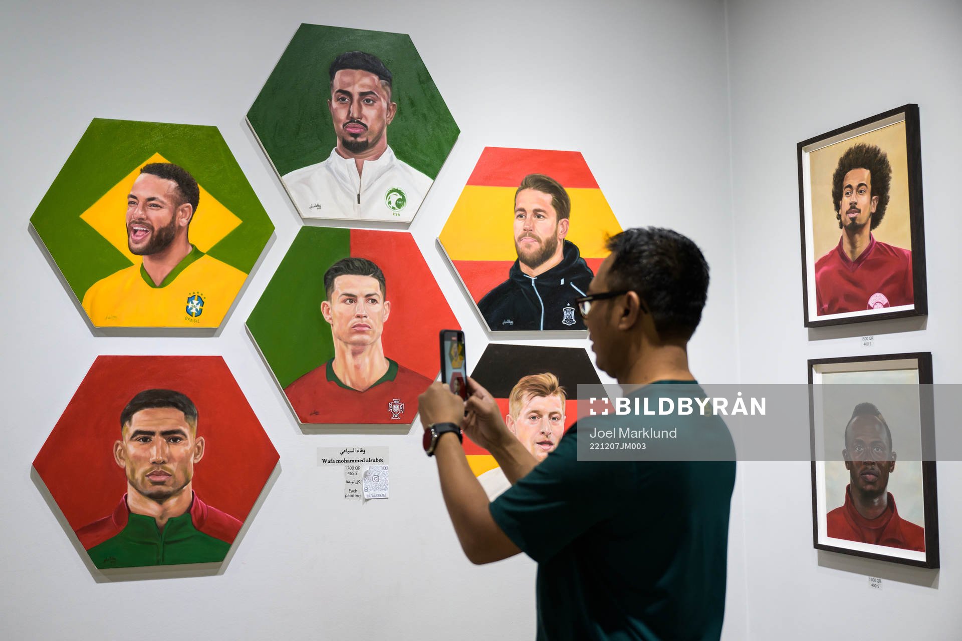 A man shoots video of paintings of football stars