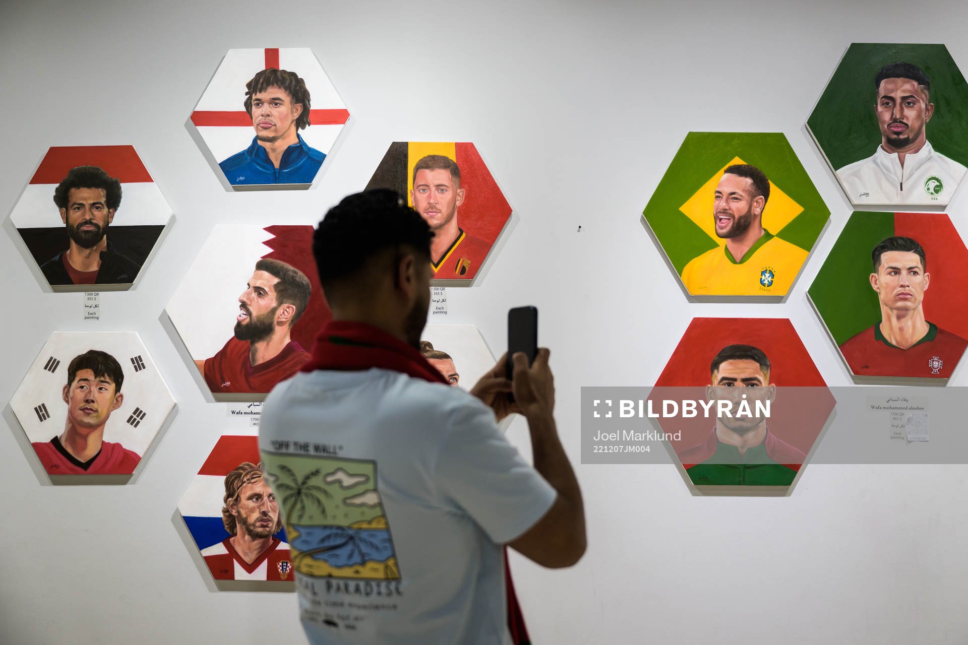 A man shoots video of paintings of football stars