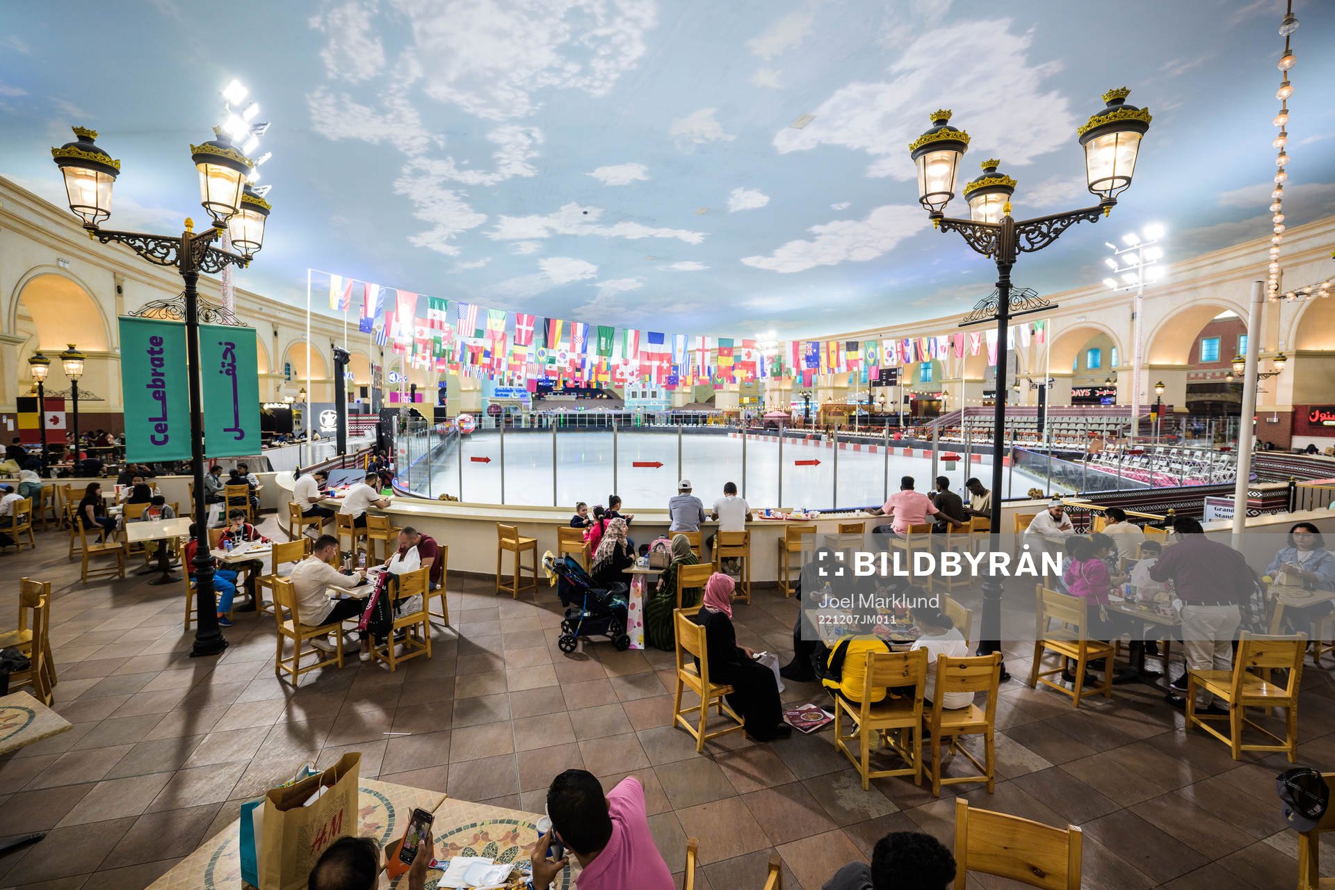 People dine next to an indoor ice skating rink at Villaggio