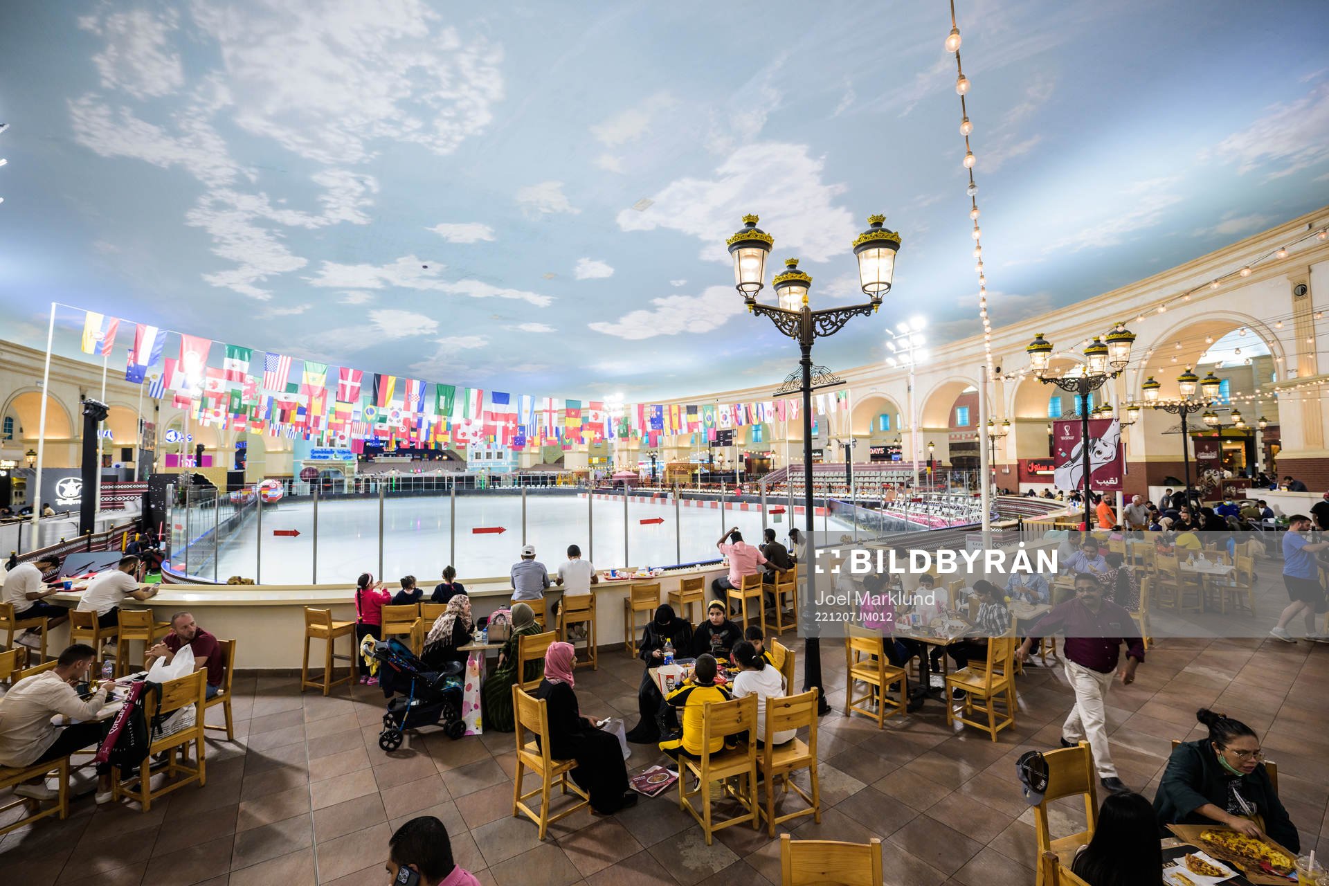 People dine next to an indoor ice skating rink at Villaggio