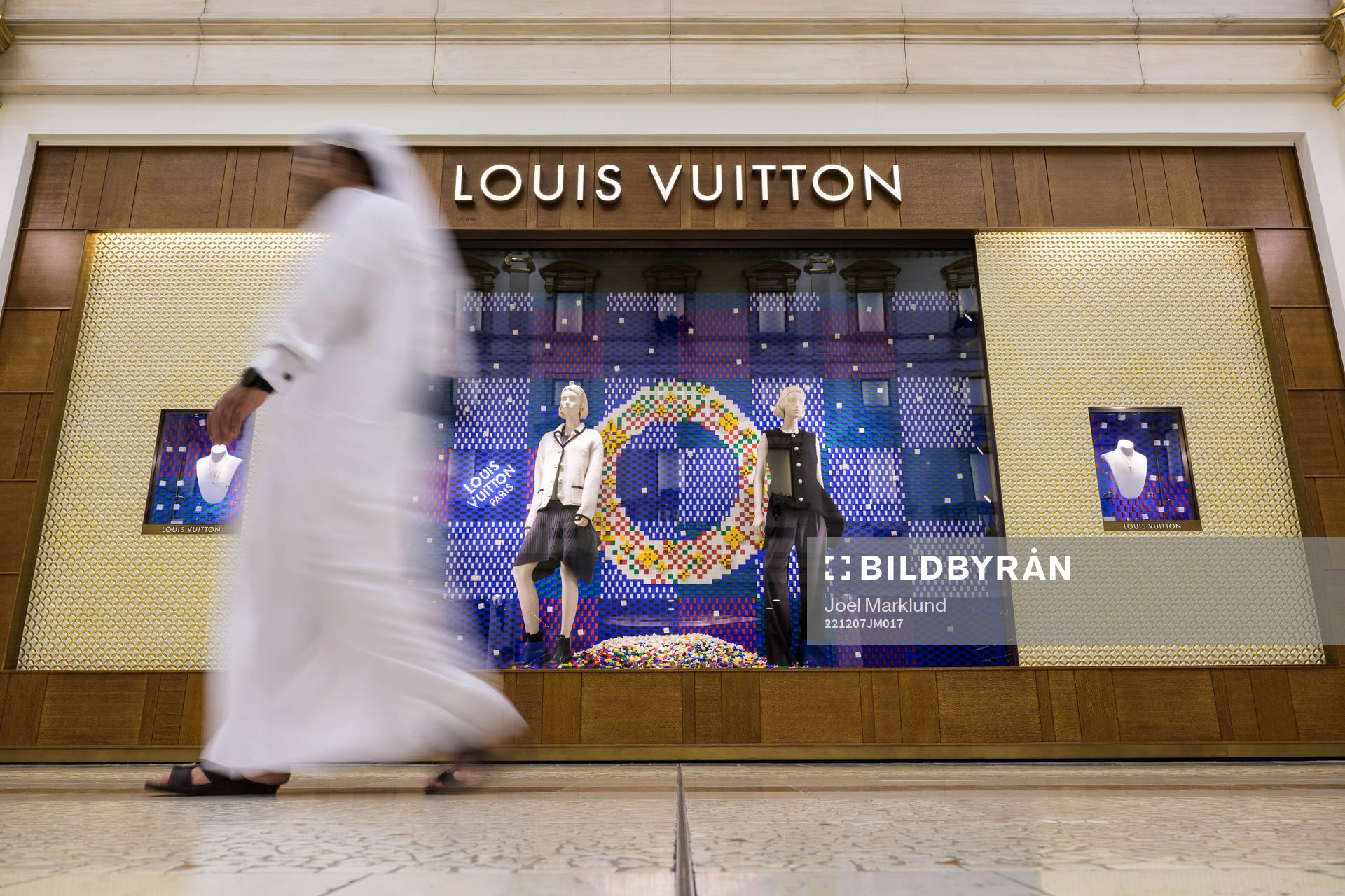 A man walks past a Louis Vuitton store at Villaggio Mall