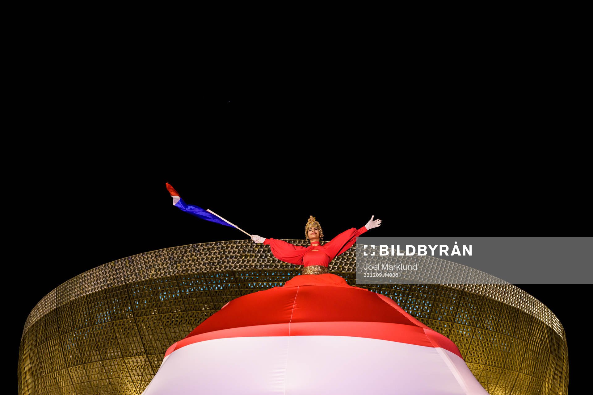 A performer waves a Dutch flag outside Lusail Stadium