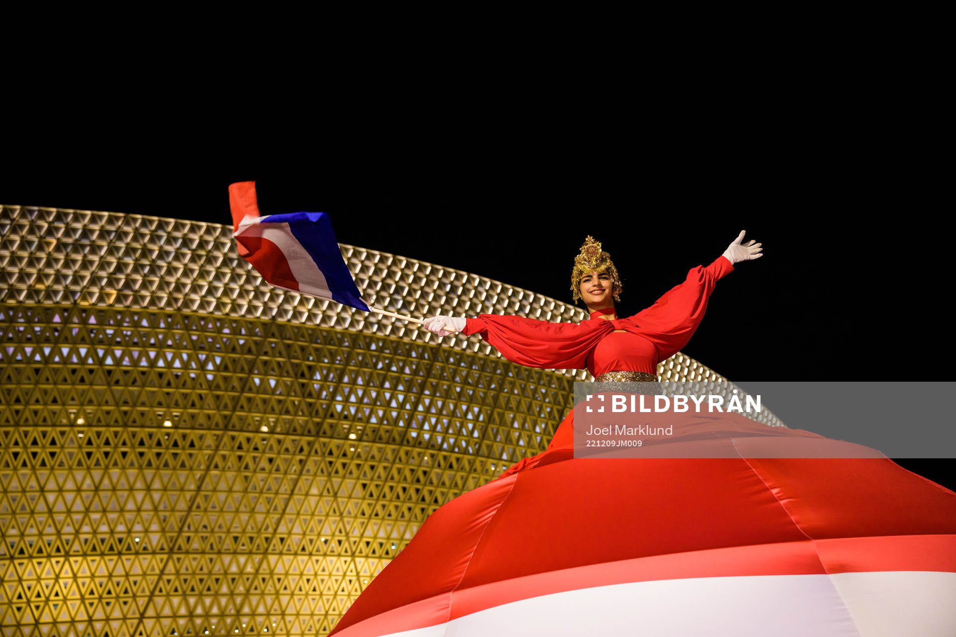 A performer waves a Dutch flag outside Lusail Stadium