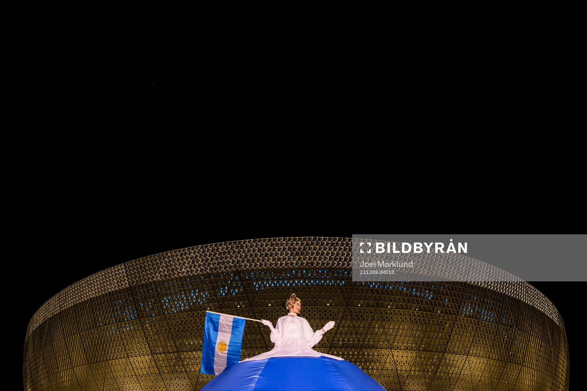 A performer waves an Argentinian flag outside Lusail Stadium