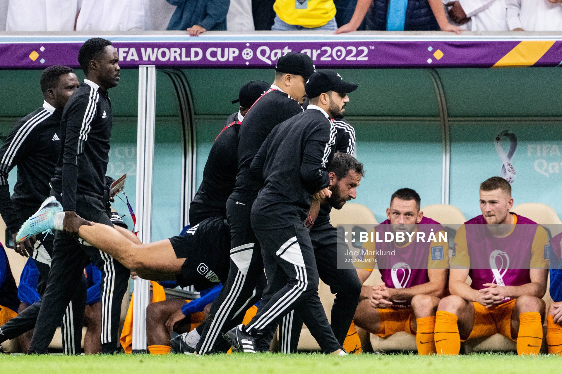 A pitch invader is detained by security