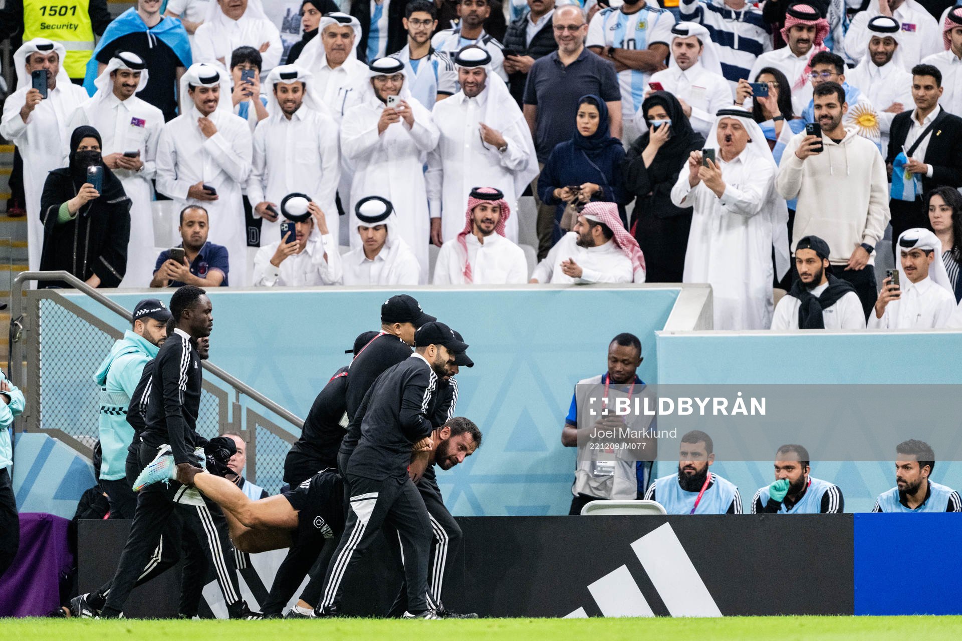A pitch invader is detained by security
