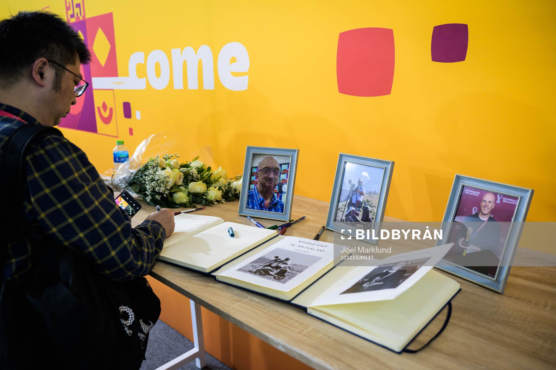 A journalist writes in a condolence book for the members of