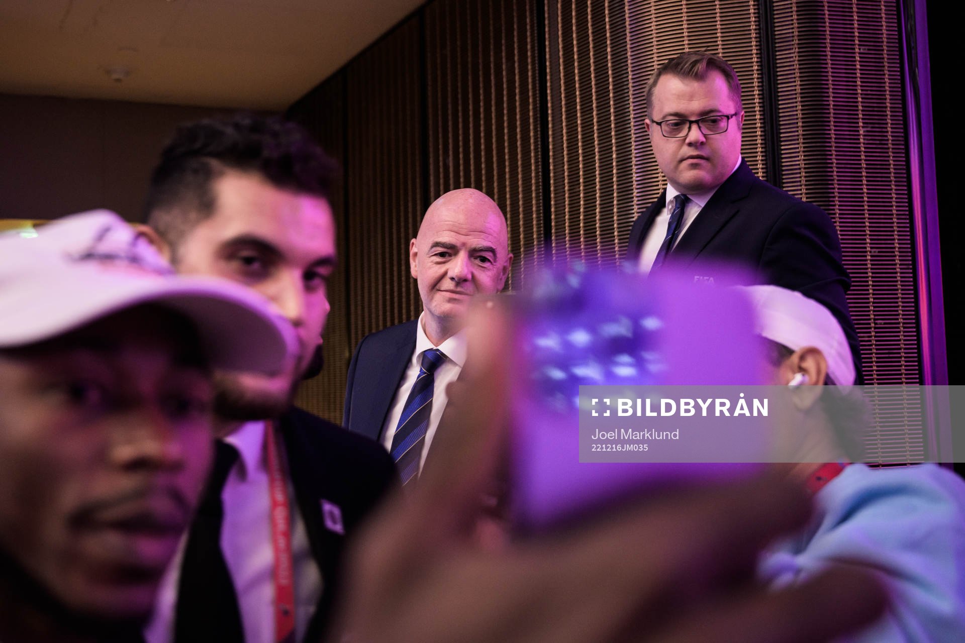 Two members of media take selfies with Gianni Infantino,