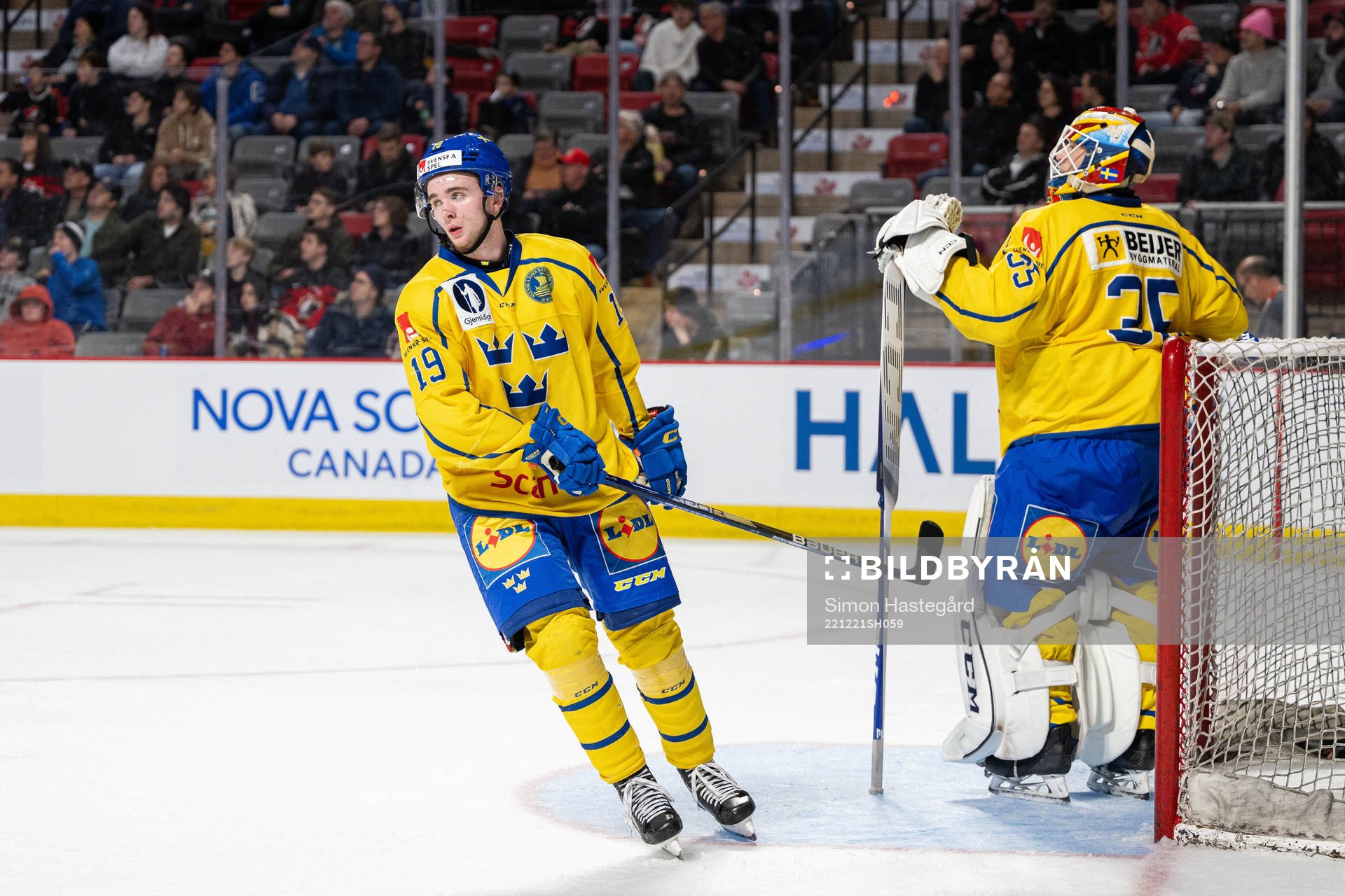 Isak Rosén and goaltender Carl Lindbom of Sweden look