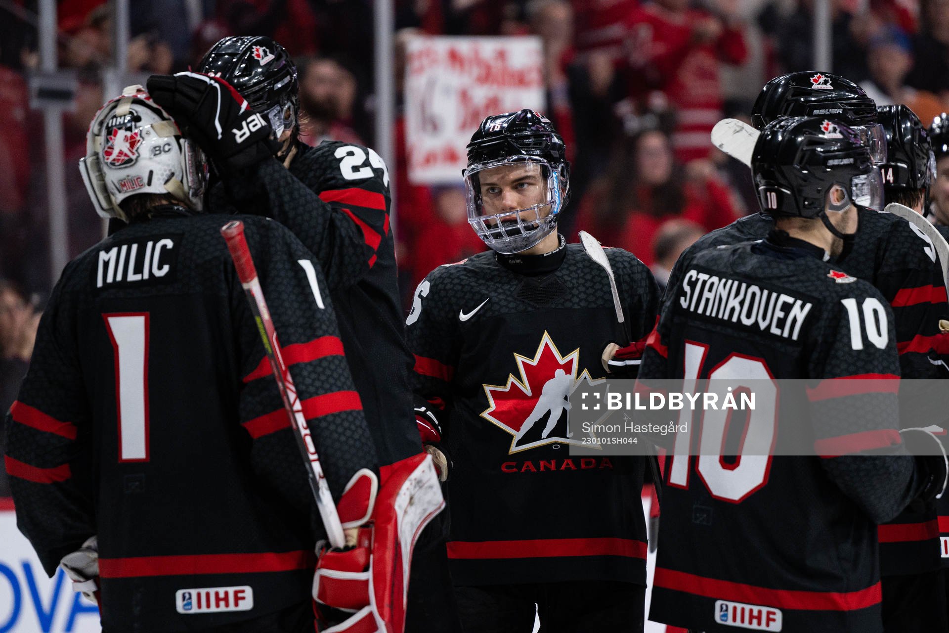 Connor Bedard and goalkeeper Thomas Milic of Canada