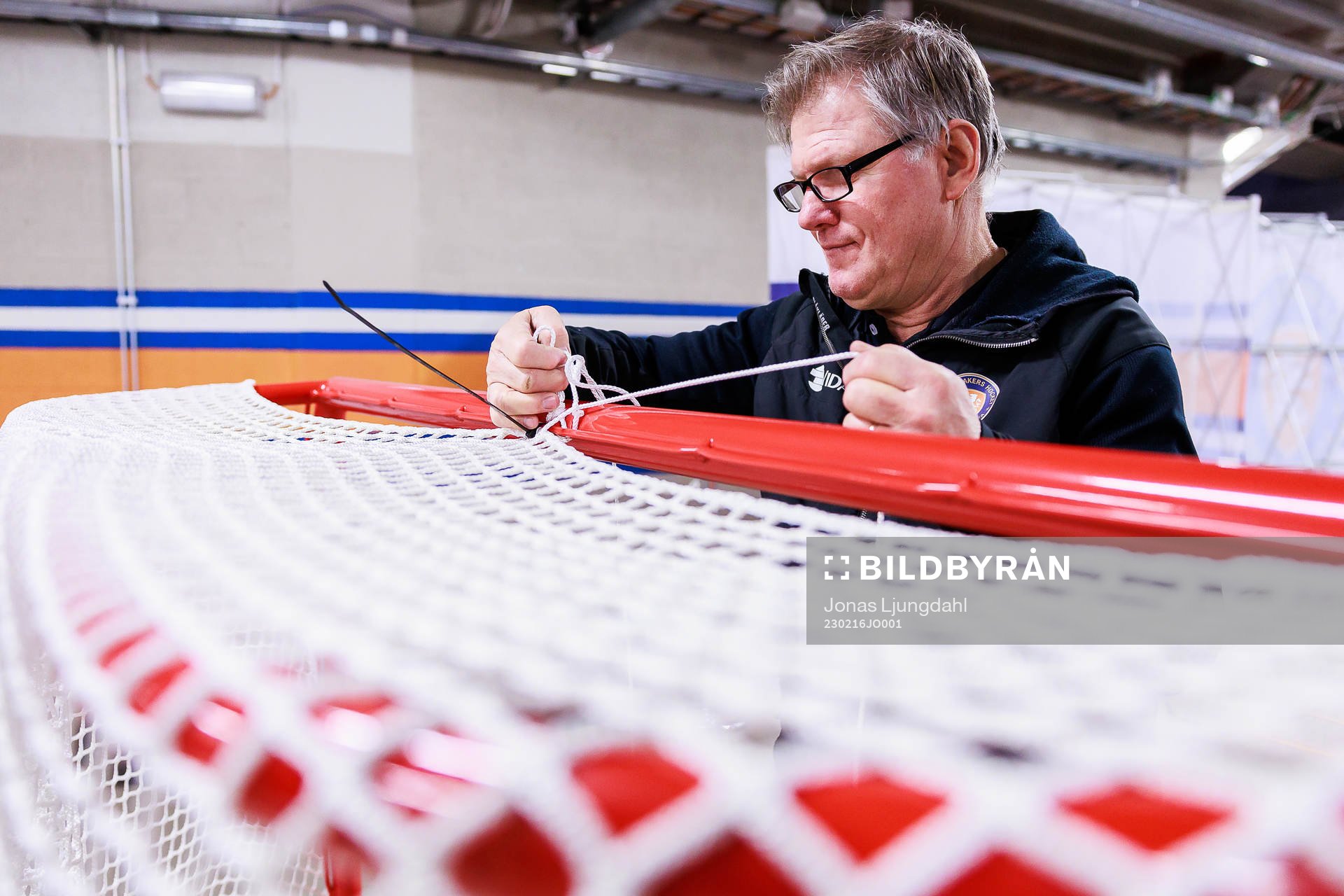 Vaktmästare Göran Krantzmonterar nät på målbur före