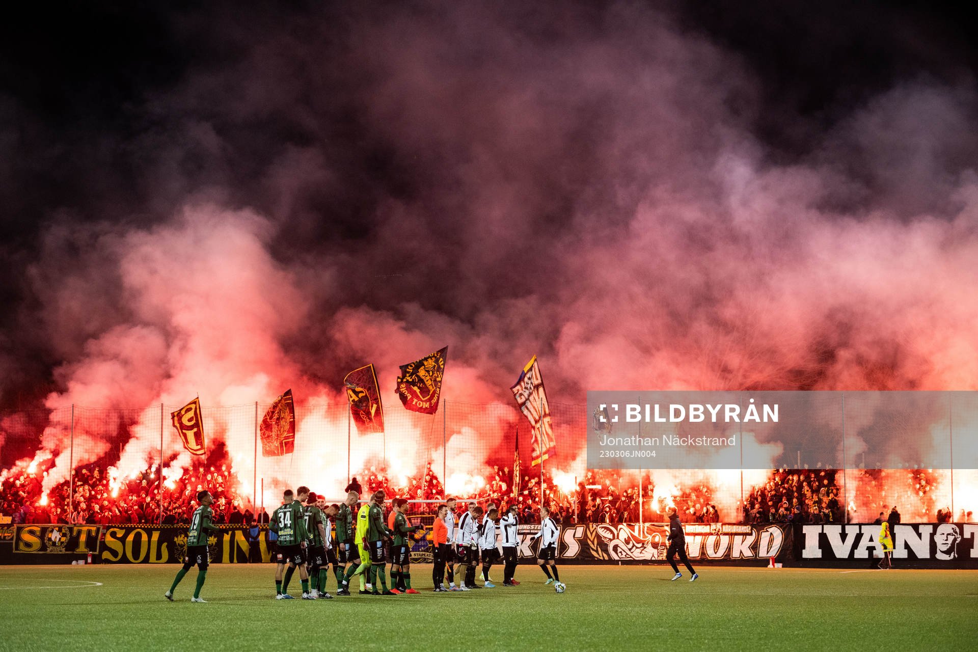 Varbergs och AIKs spelare framför supportar med bengaliska