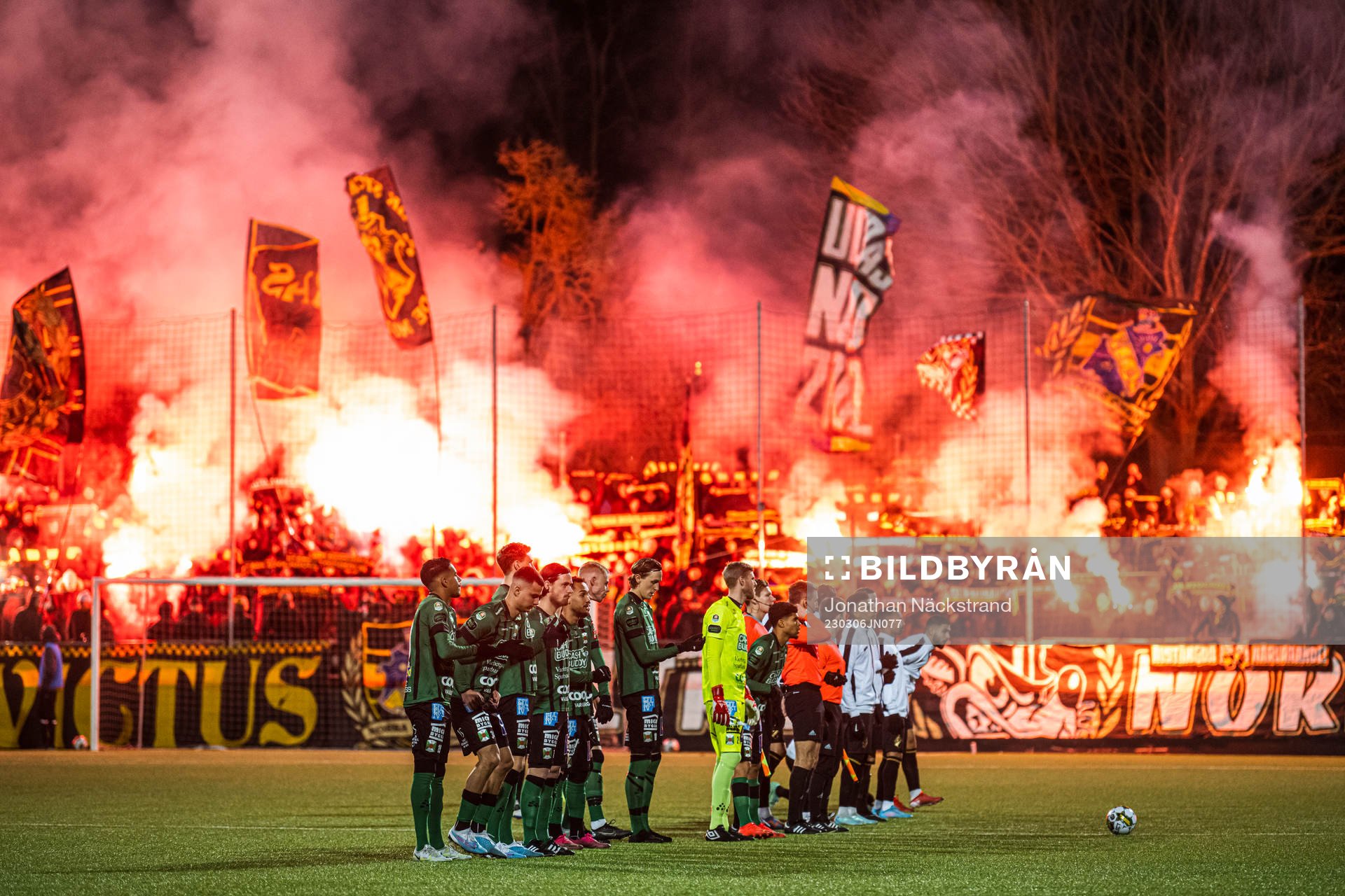 Varbergs och AIKs spelare framför supportar med bengaliska eldar inför fotbollsmatchen i Svenska Cupen mellan AIK och Varberg den 6 mars 2023 i Stockholm.