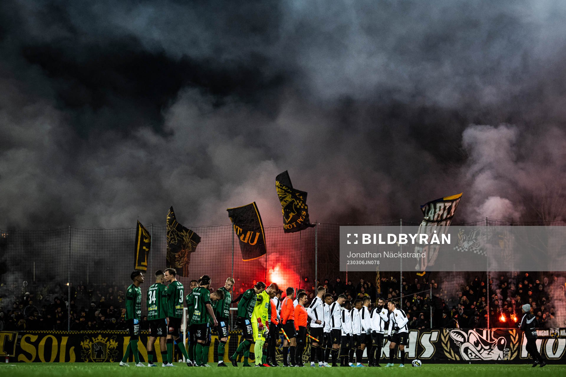 Varbergs och AIKs spelare framför supportar med bengaliska eldar inför fotbollsmatchen i Svenska Cupen mellan AIK och Varberg den 6 mars 2023 i Stockholm.