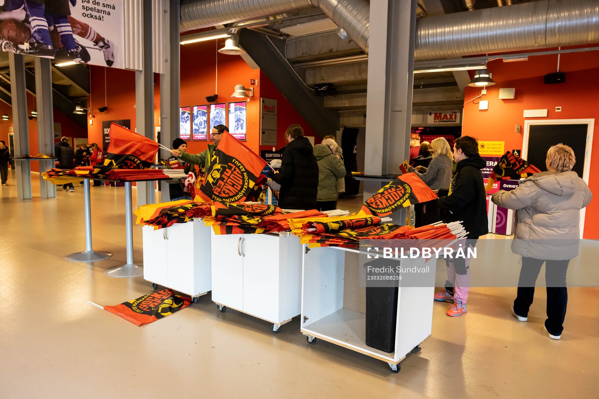 Flaggor delas ut bakom läktaren