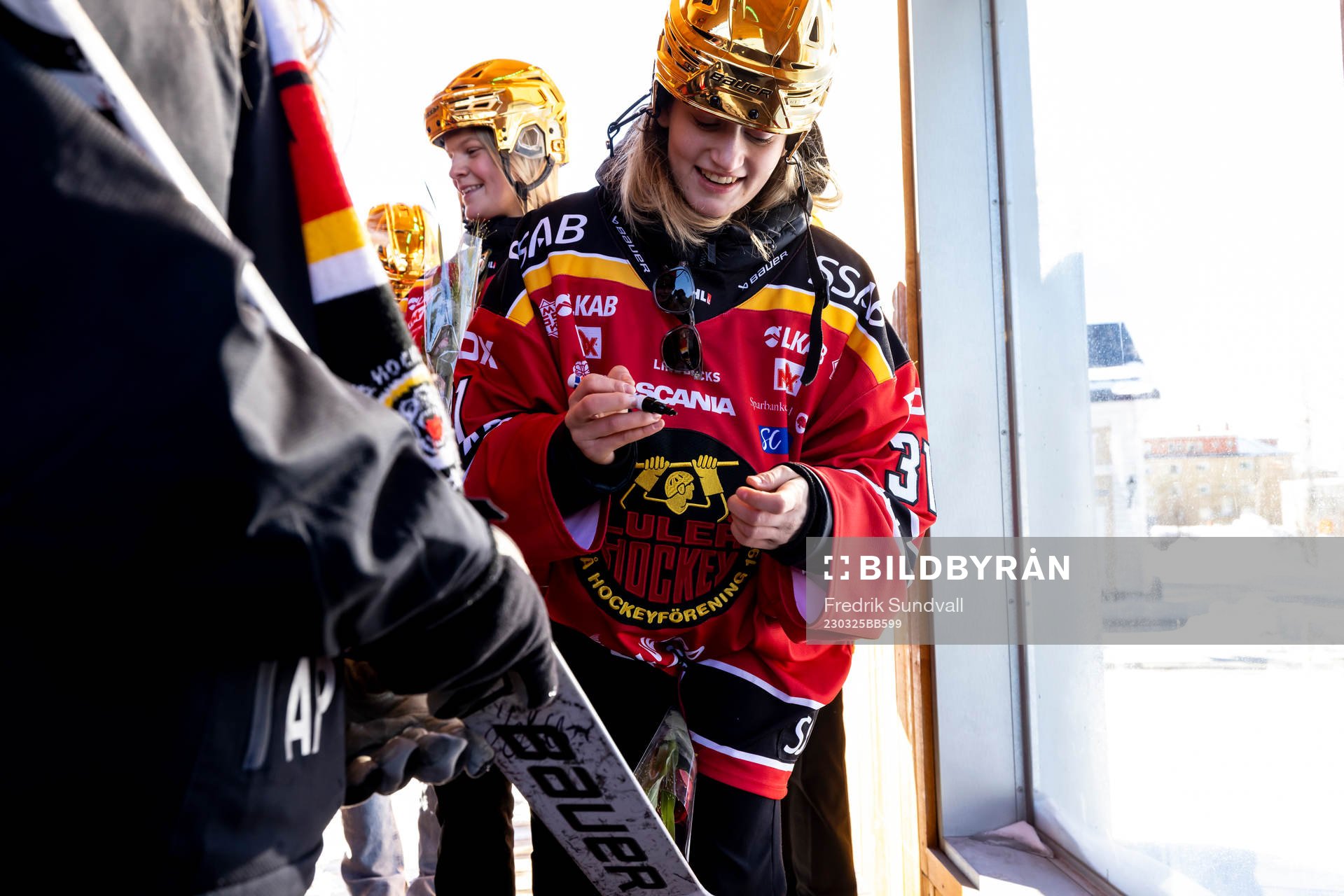 Frida Axell skriver autograf på klubba
