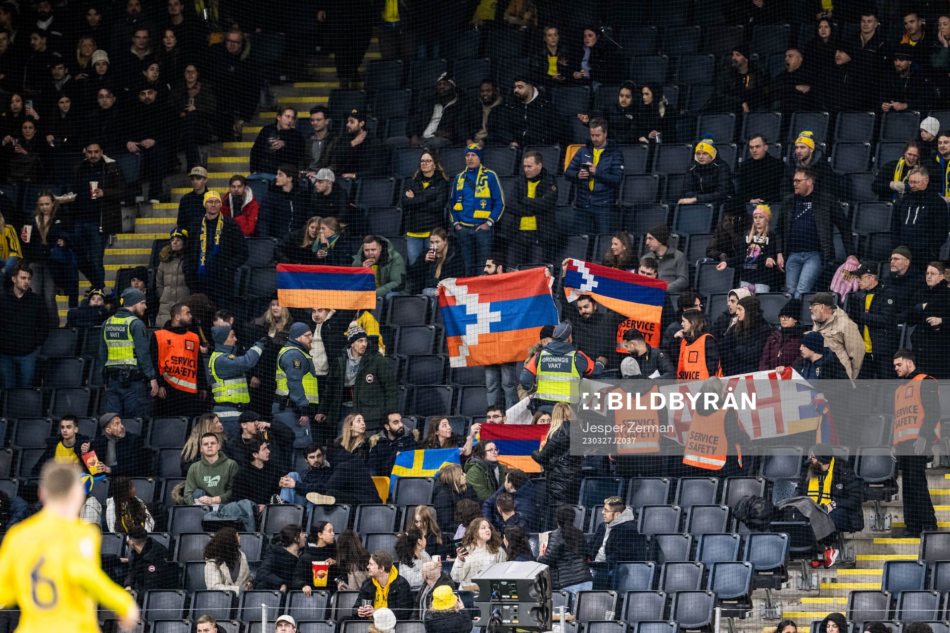 Security guards in the stands with fans holding up a