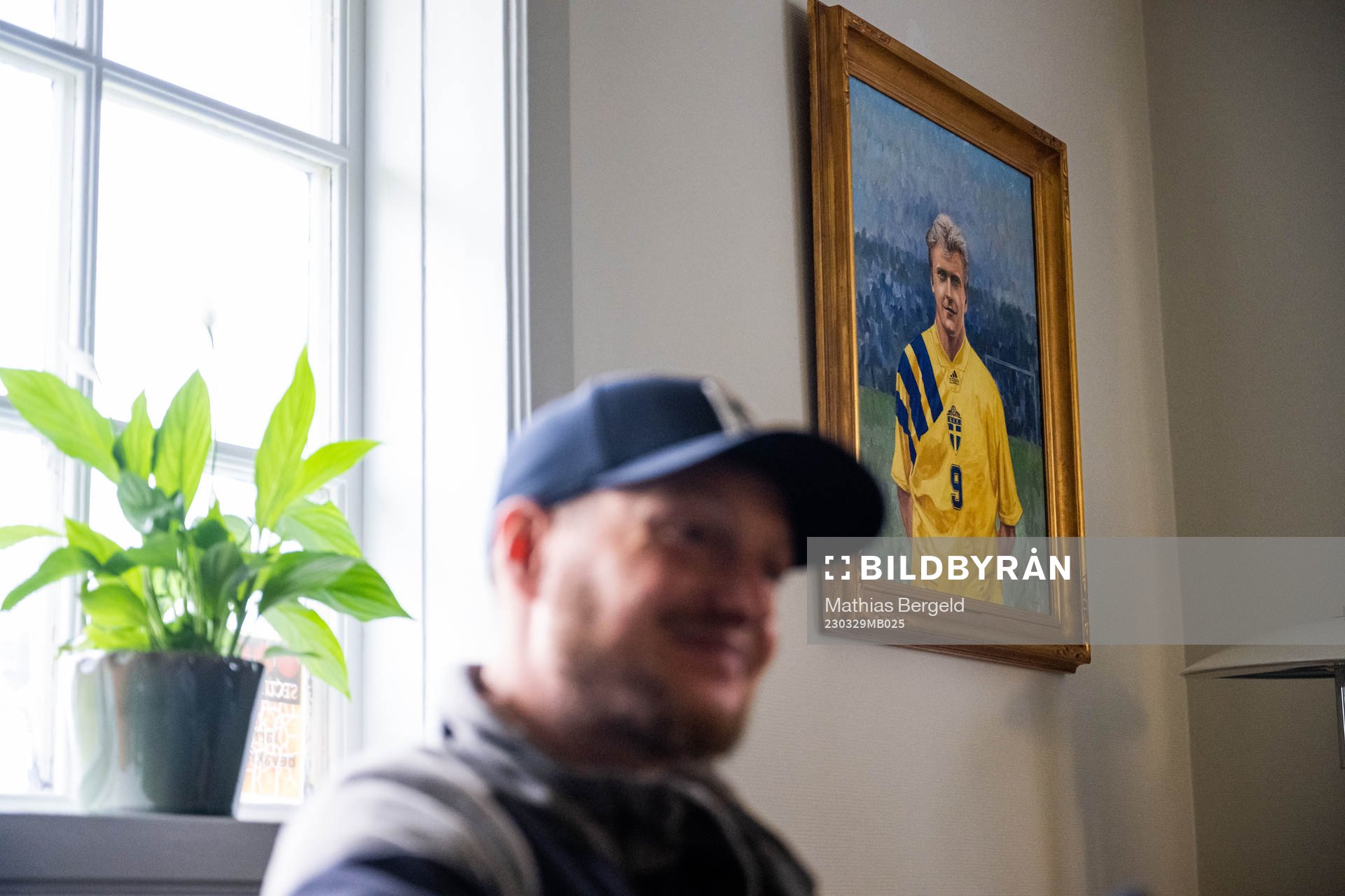 Ett porträtt av Jonas Thern hänger på väggen bakom