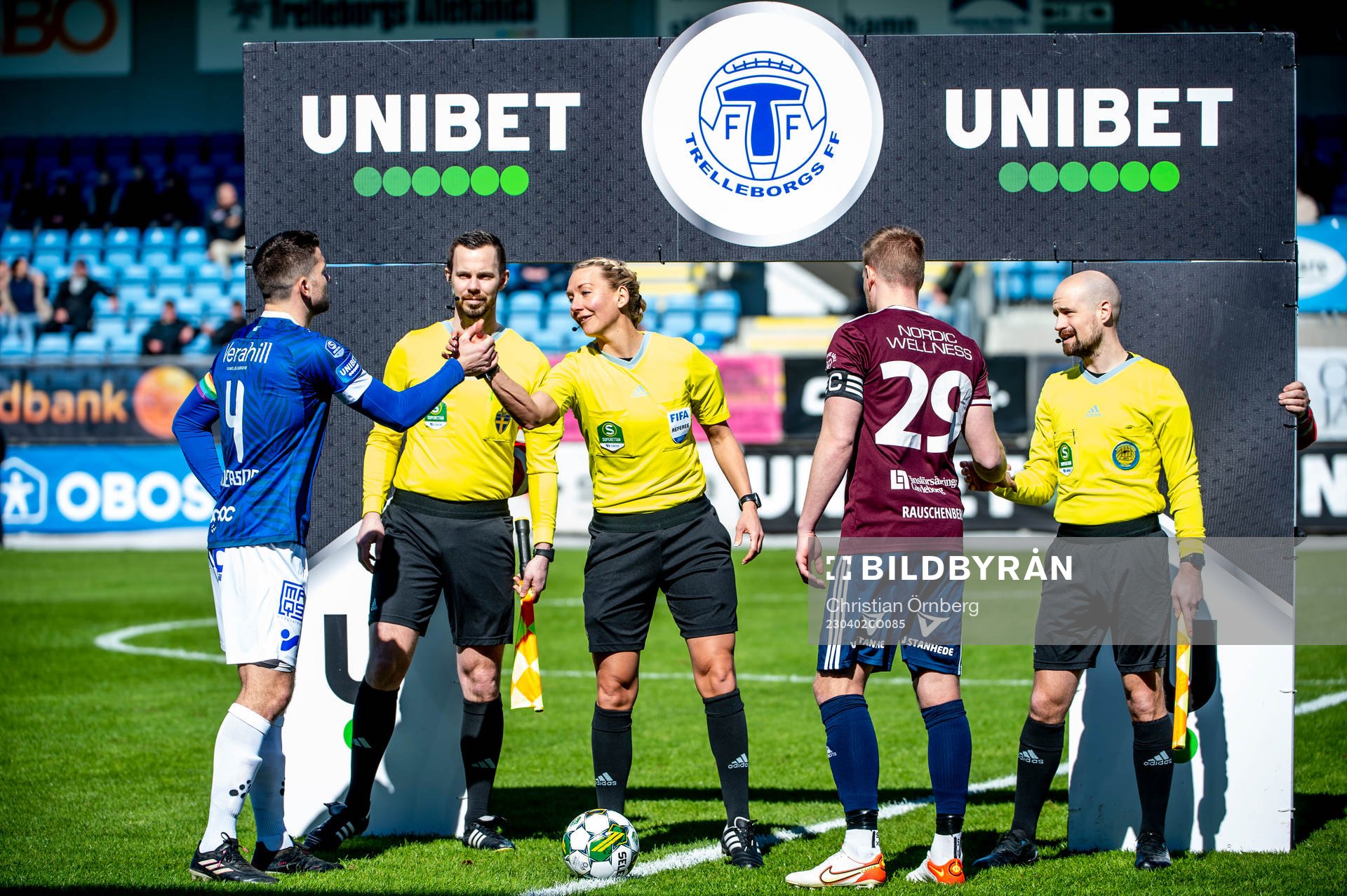 Trelleborgs Mattias Andersson och Gefles Martin Rauschenberg Brorsen singlar slant framför domare Tess Olofsson innan fotbollsmatchen i Superettan mellan Trelleborg och Gefle den 2 april 2023 i Trelleborg.