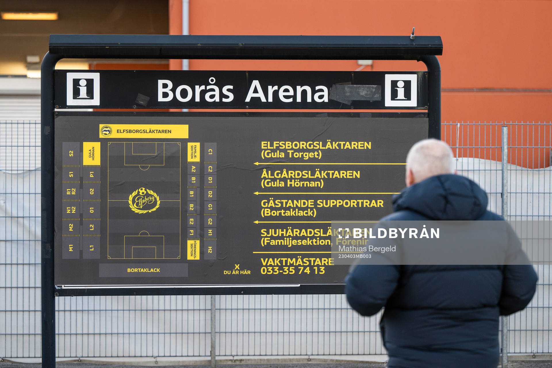 En man läser på en informationstavla för Borås Arena