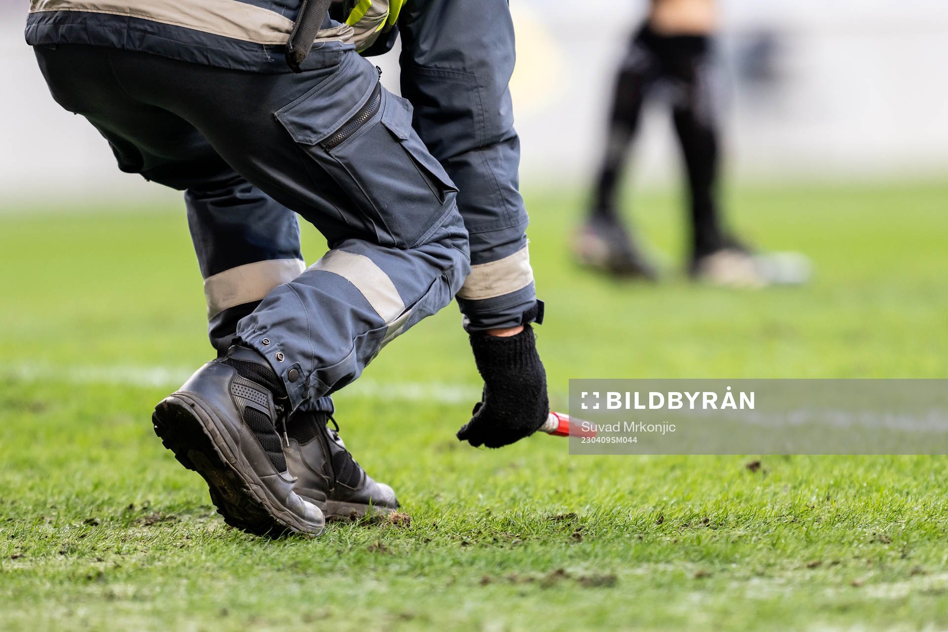 En vakt plockar upp ett inkastat föremål under fotbollsmatchen i Allsvenskan mellan Kalmar och IFK Göteborg den 9 april 2023 i Kalmar. 