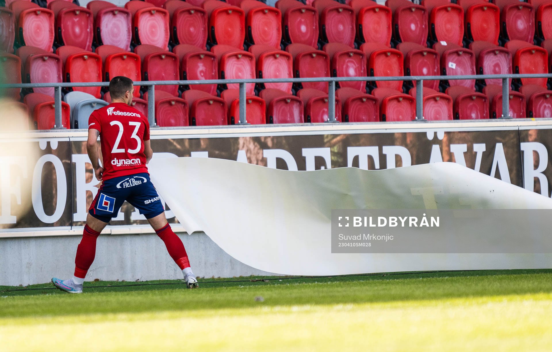 Östers Vladimir Rodic drar bort en inblåst reklamskylt under fotbollsmatchen i Superettan mellan Öster och Trelleborg den 10 april 2023 i Växjö.