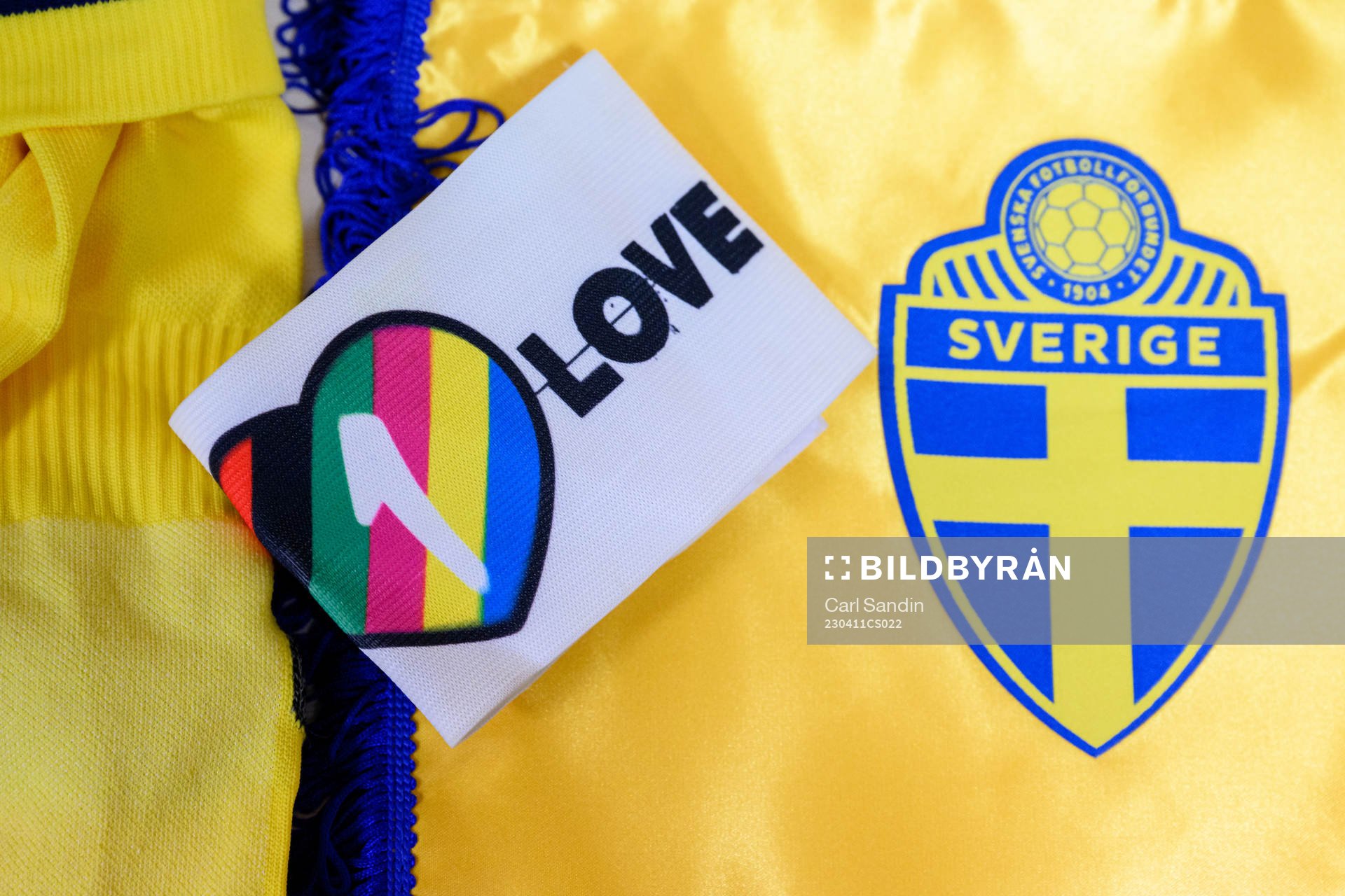 The One Love captains armband next to the logo of the