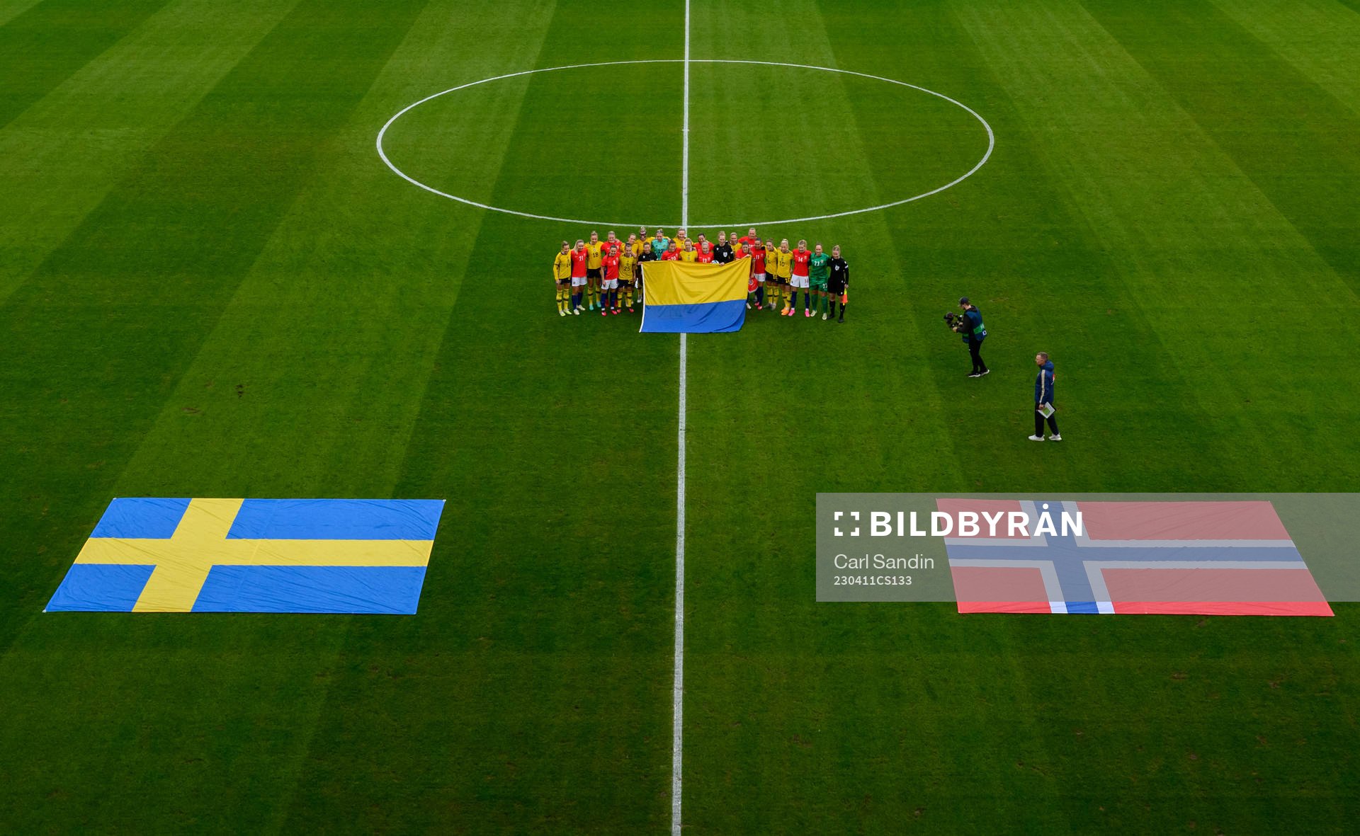 The players of Sweden and Norway hold the Ukranian flag at