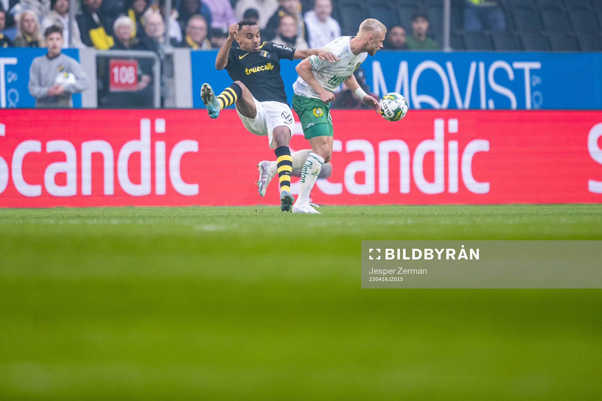 AIKs Bilal Hussein och Hammarbys Simon Strand under fotbollsmatchen i Allsvenskan mellan AIK och Hammarby den 16 april 2023 i Stockholm. 