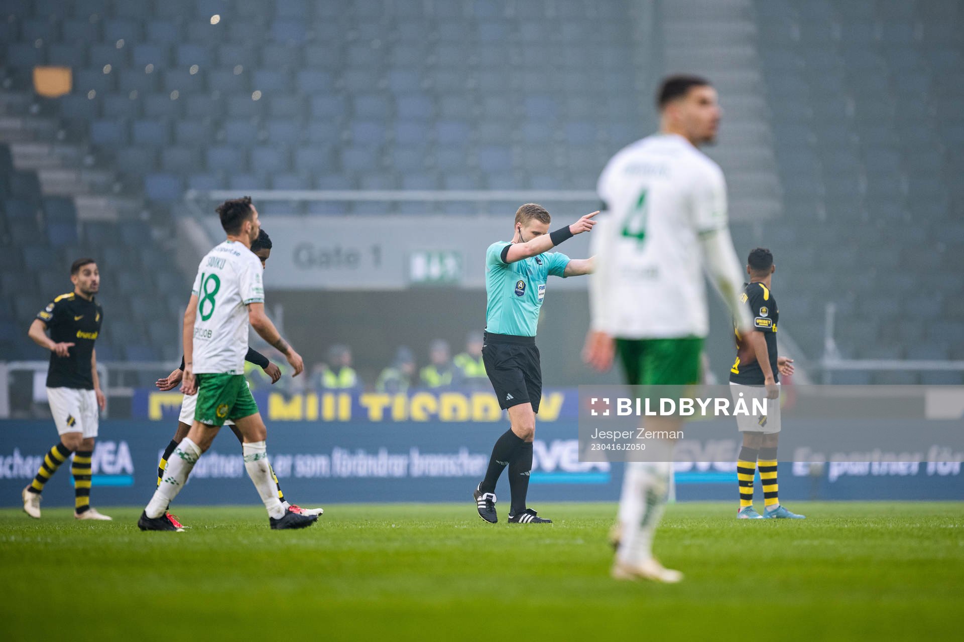 Domare Glenn Nyberg signalerar för spelarna att lämna planen på grund av knallskott under fotbollsmatchen i Allsvenskan mellan AIK och Hammarby den 16 april 2023 i Stockholm.