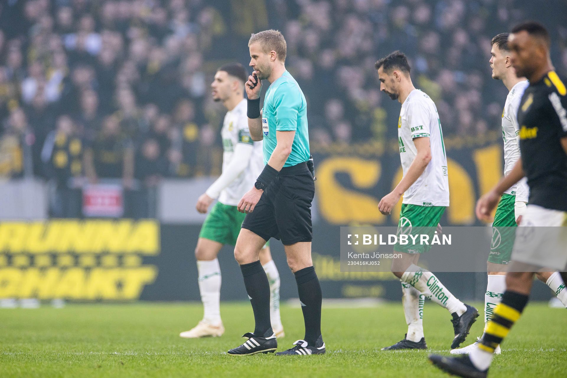 Domare Glenn Nyberg lämnar planen då matchen pausats på