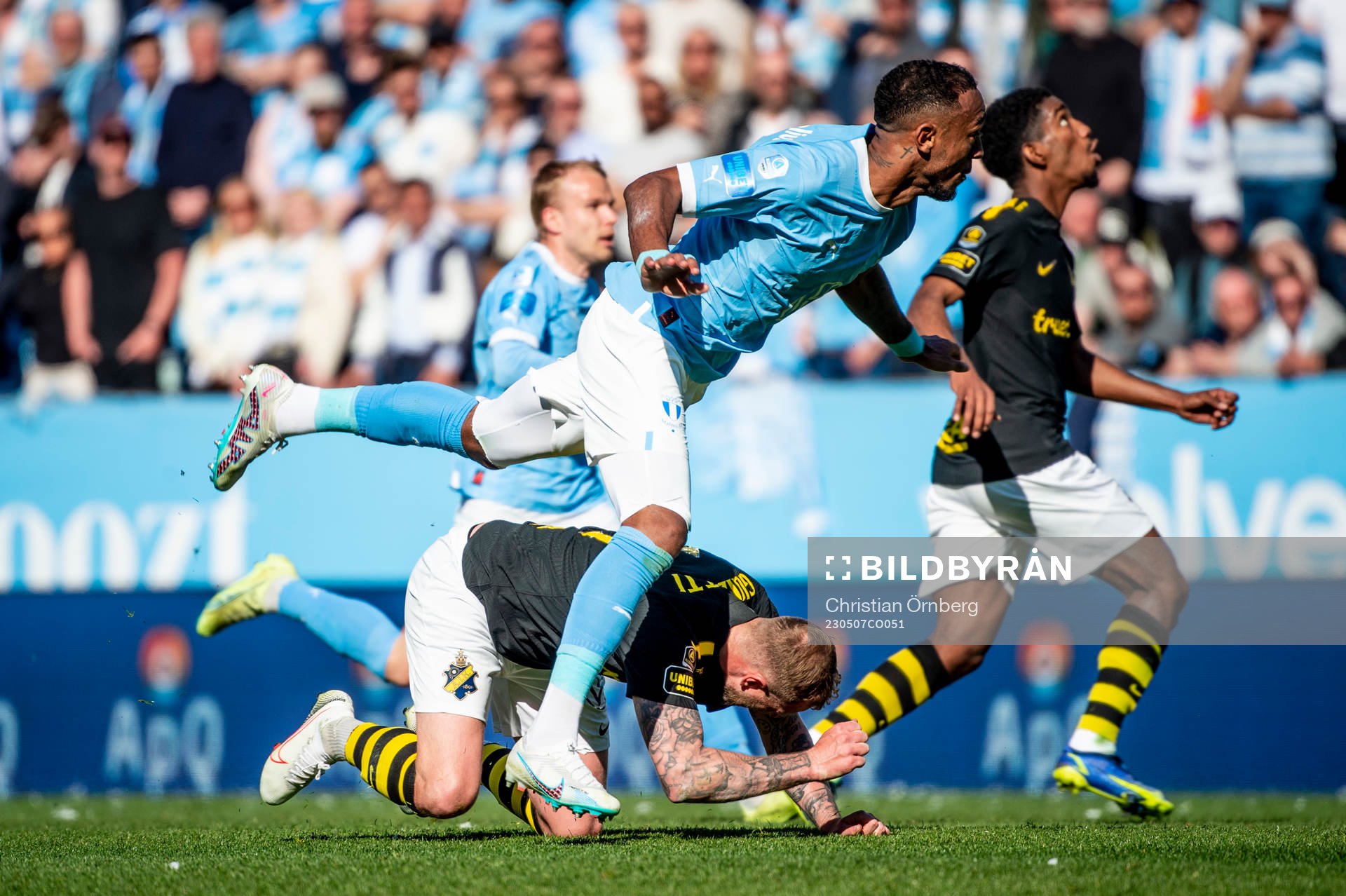 AIKs John Guidetti får en smäll i en närkamp med Malmö FFs Derek Cornelius under fotbollsmatchen i Allsvenskan mellan Malmö FF och AIK den 7 maj 2023 i Malmö.