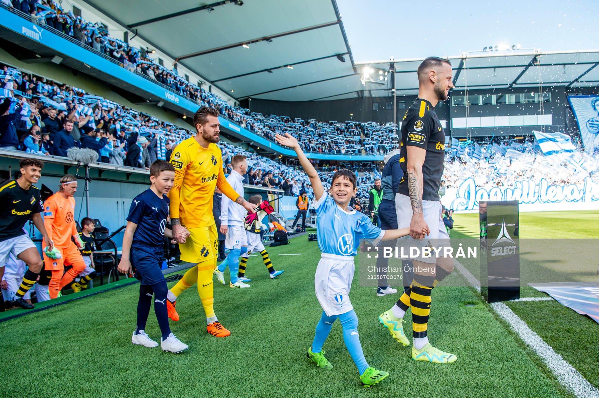 Spelarna kommer in på arenan innan fotbollsmatchen i
