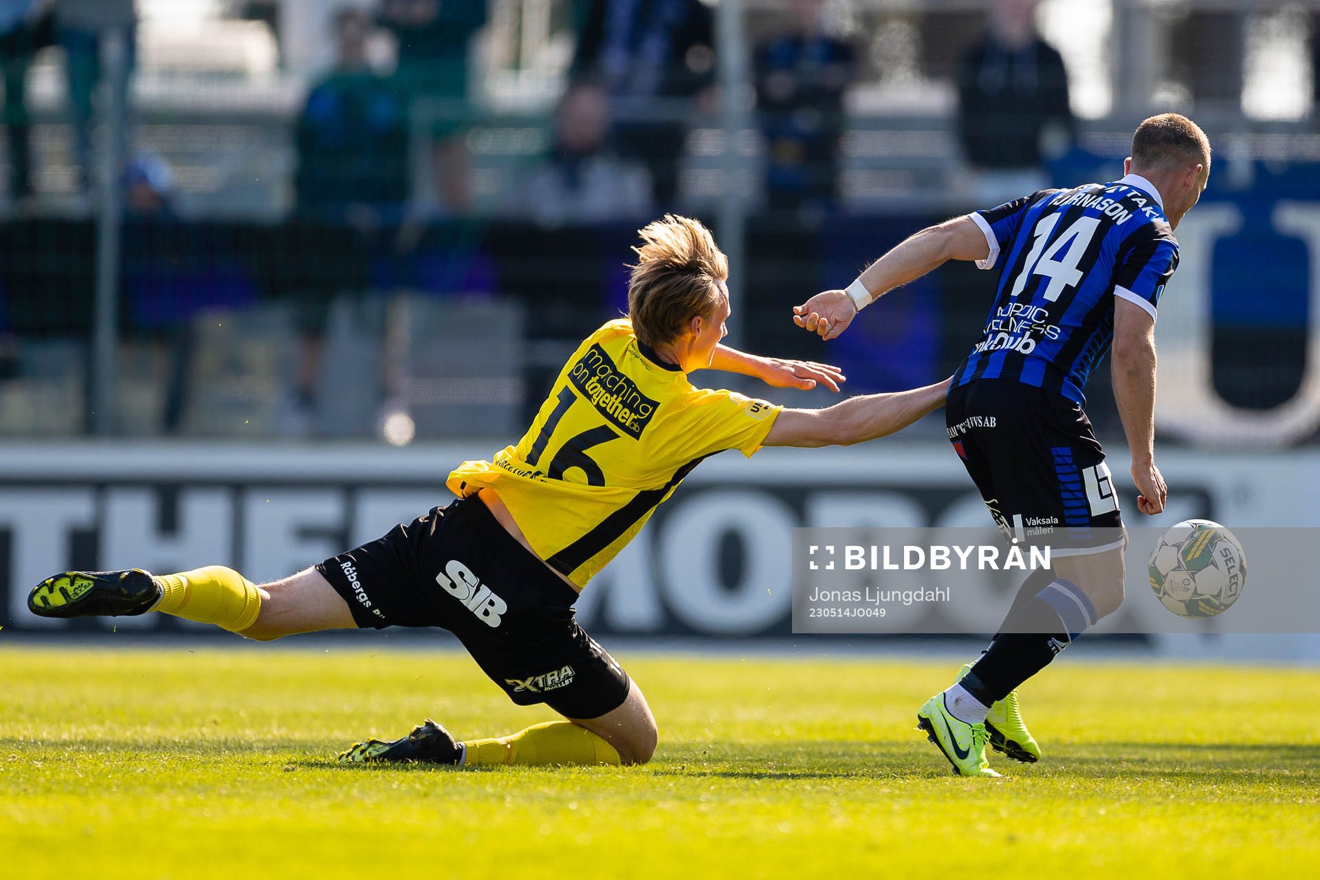 Mjällbys Alexander Johansson faller i kamp med Sirius Aron Bjarnason under fotbollsmatchen i Allsvenskan mellan Mjällby och Sirius den 14 maj 2023 i Hällevik.