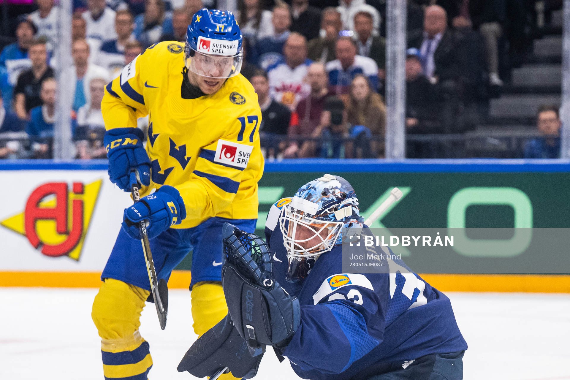 Pär Lindholm of Sweden and goaltender Emil Larmi of Finland