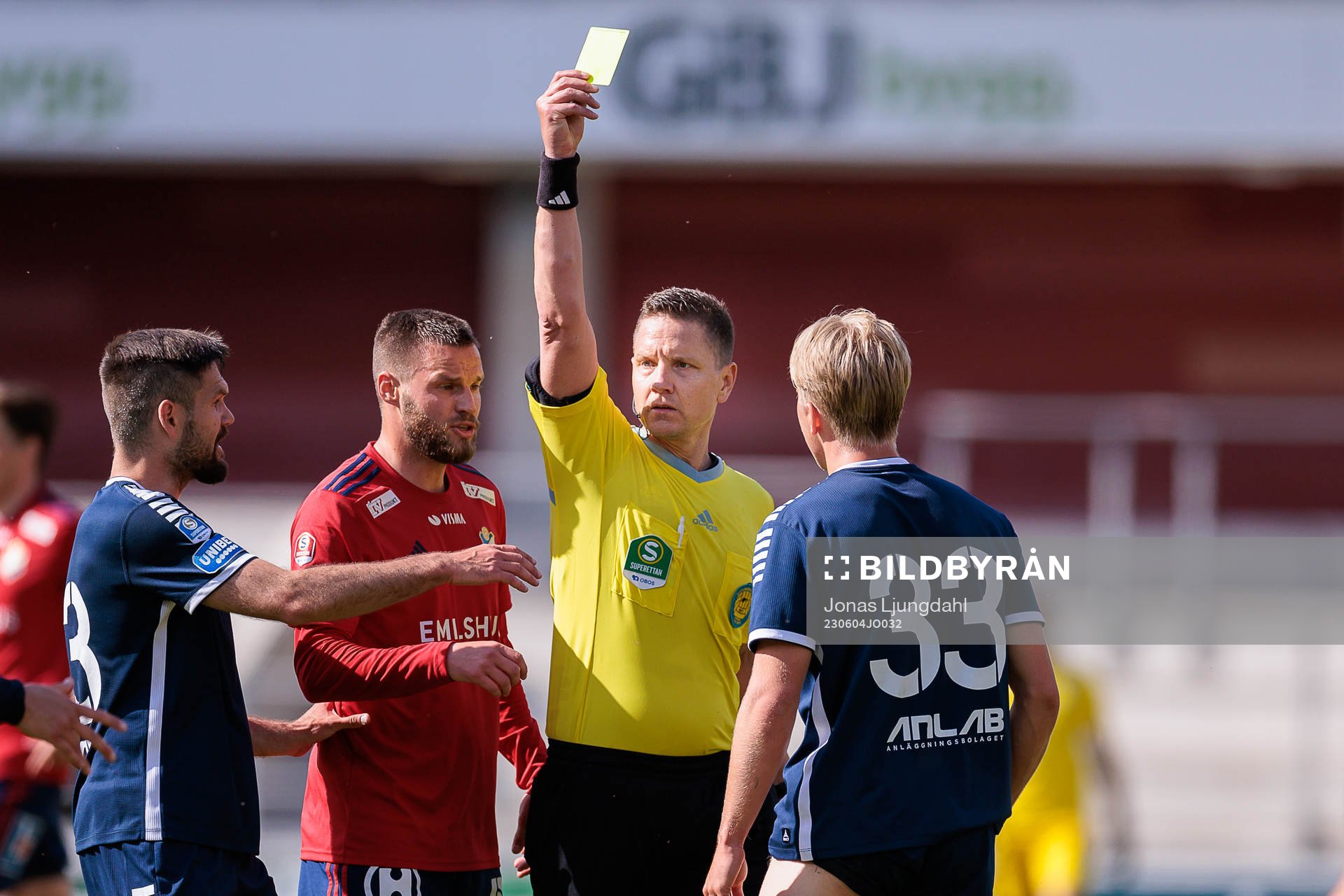 Domare Martin Strömbergsson delar ut ett gult kort till