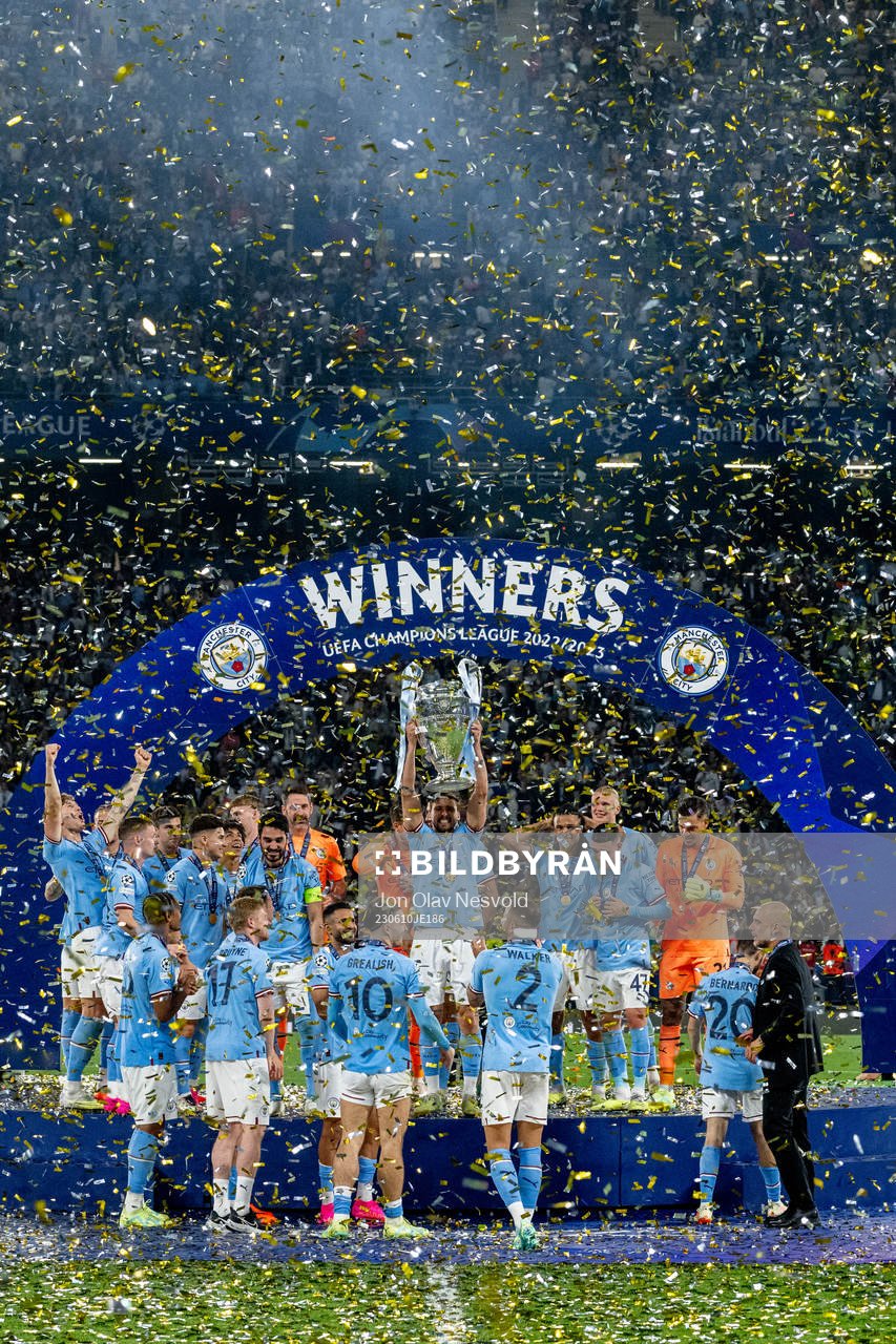 Players of Manchester City celebrate with the trophy
