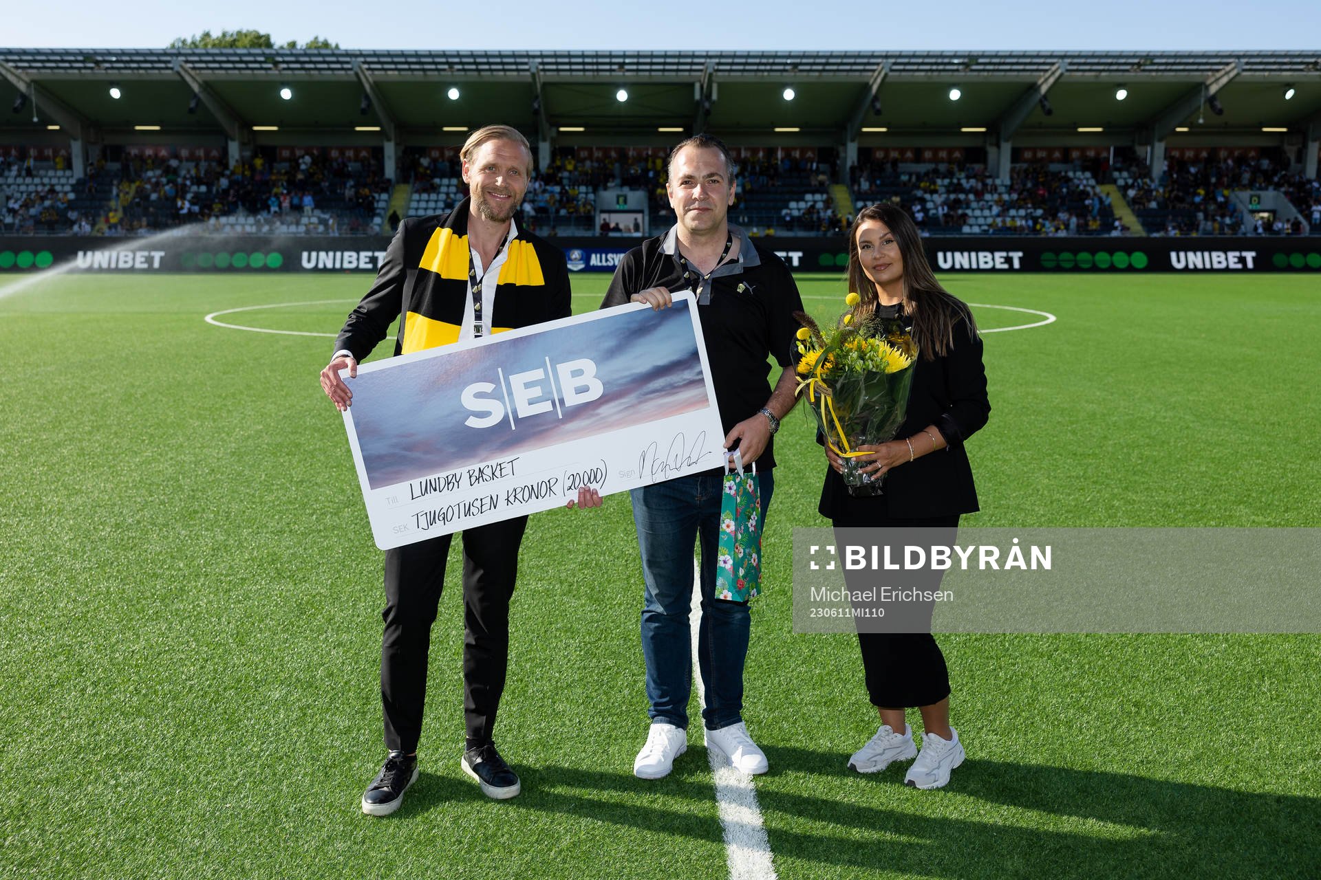 Häckens klubbdirektör Marcus Jodin och projektledare Panteha Milanian delar ut en check till Lundby Basket i pausen under fotbollsmatchen i Allsvenskan mellan Häcken och Mjällby den 11 juni 2023 i Göteborg.