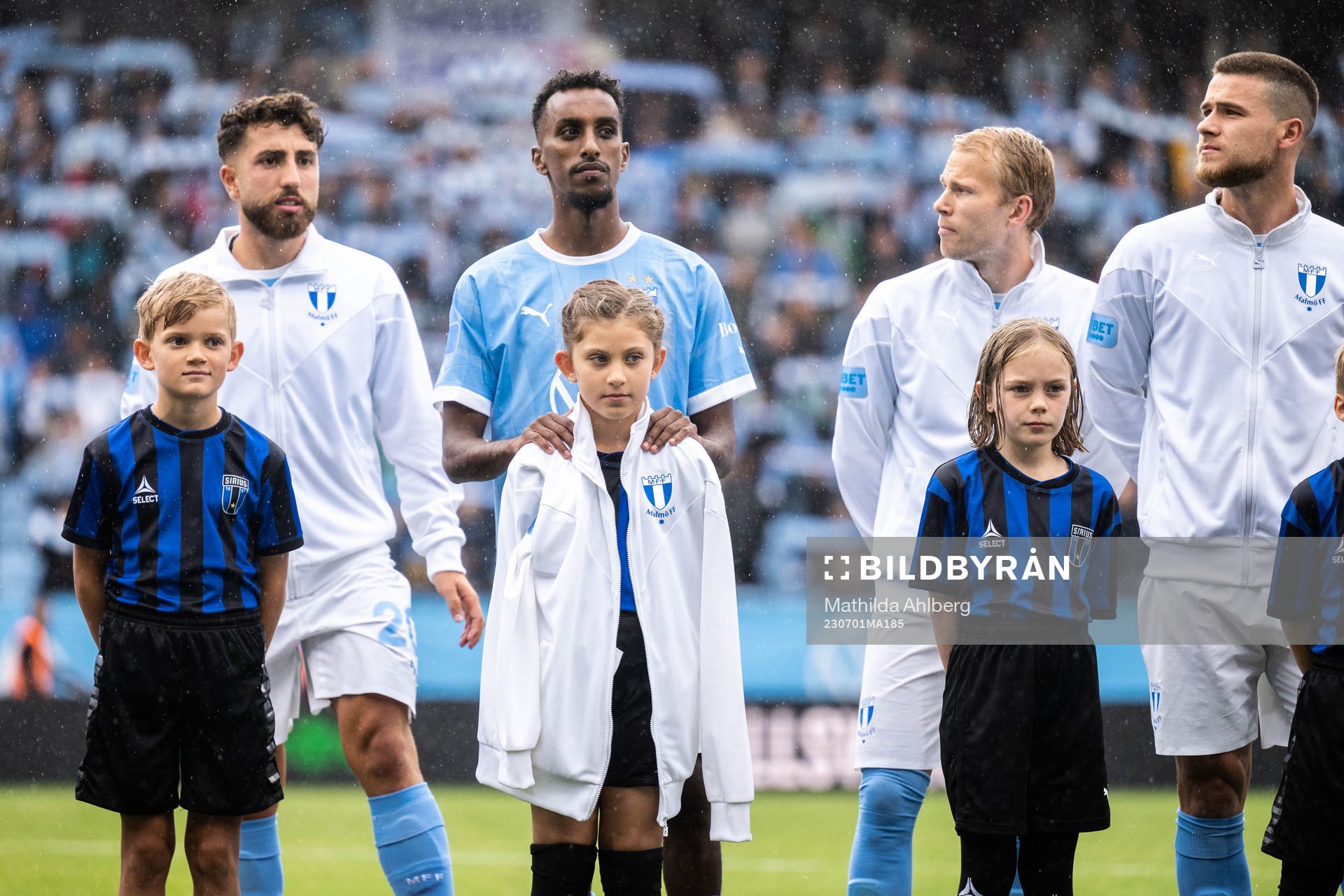 Malmö FFs Taha Ali ger sin överdragsjacka till en maskot