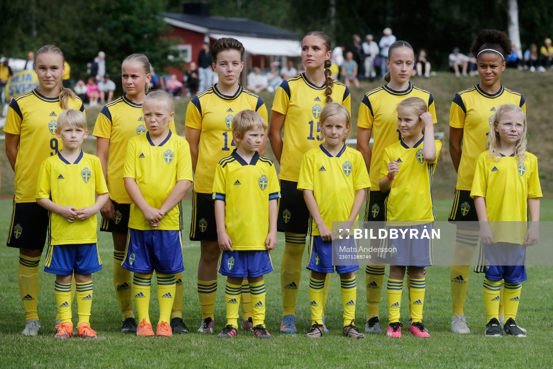 Maskotar i landslagsdress vid lineup innan fotbollsmatchen
